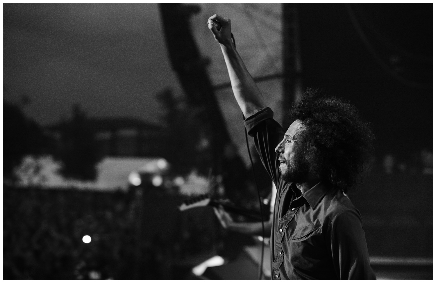 Zack de la Rocha on stage with arm raised at Rage Against the Machine at the Finsbury Park Christmas number one concert