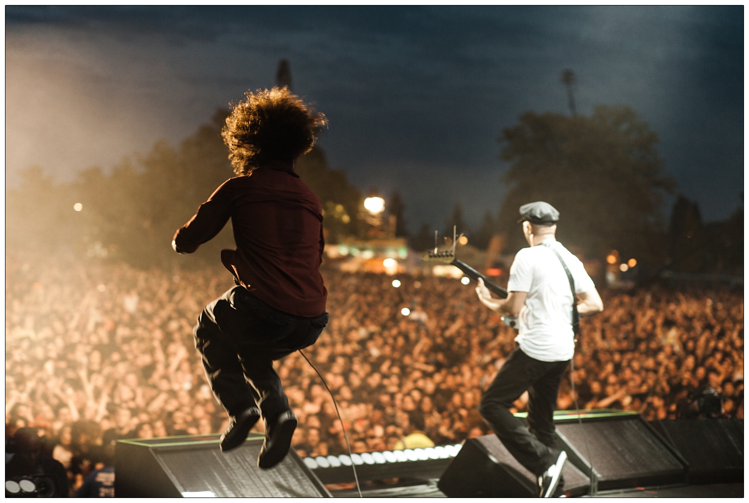 View of the crowd, Zack de la Rocha jumping, and Tom Morello at Rage Against the Machine gig from the stage at Finsbury Park.