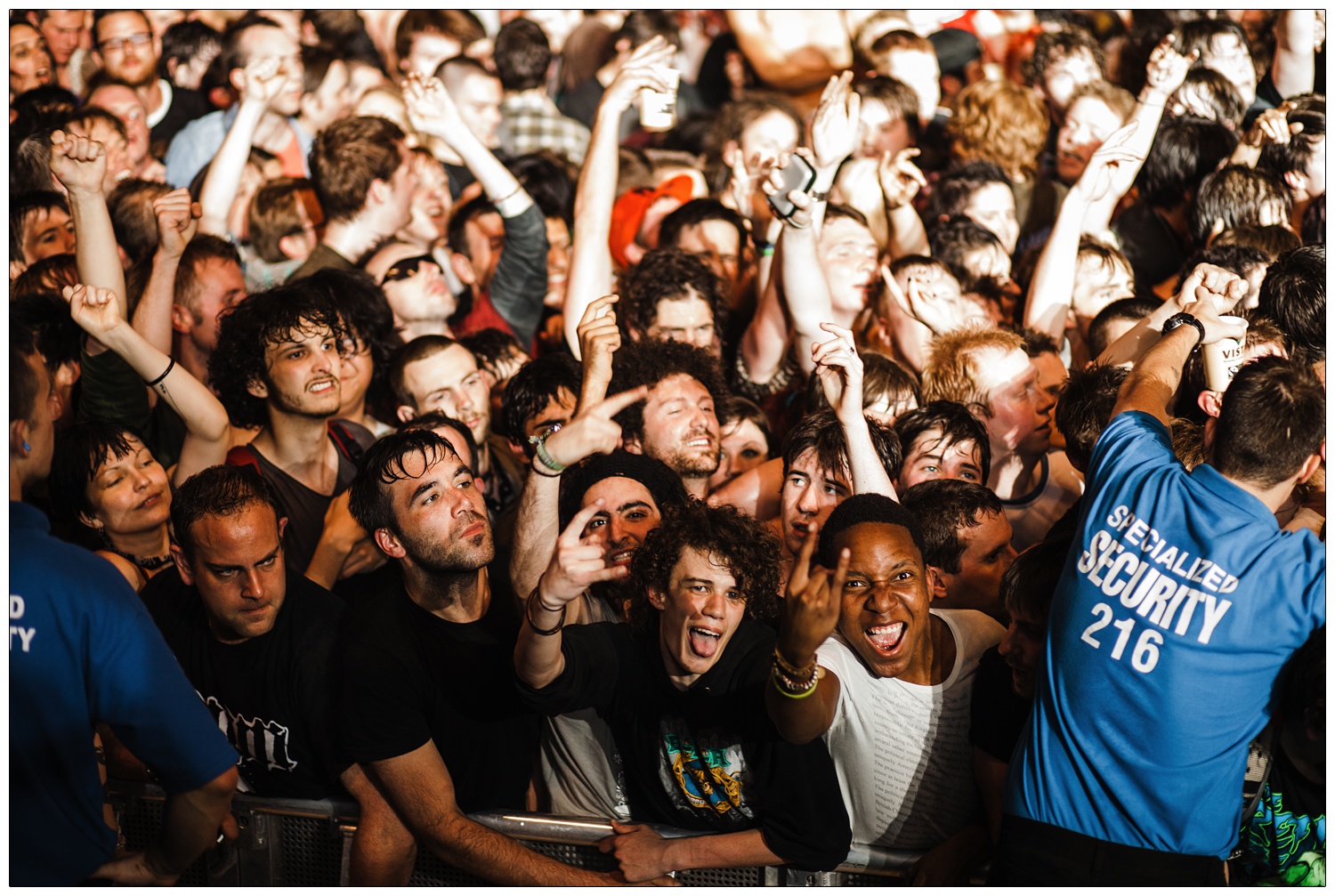 Crowd doing rock fingers at the camera and security at RATM gig in 2010