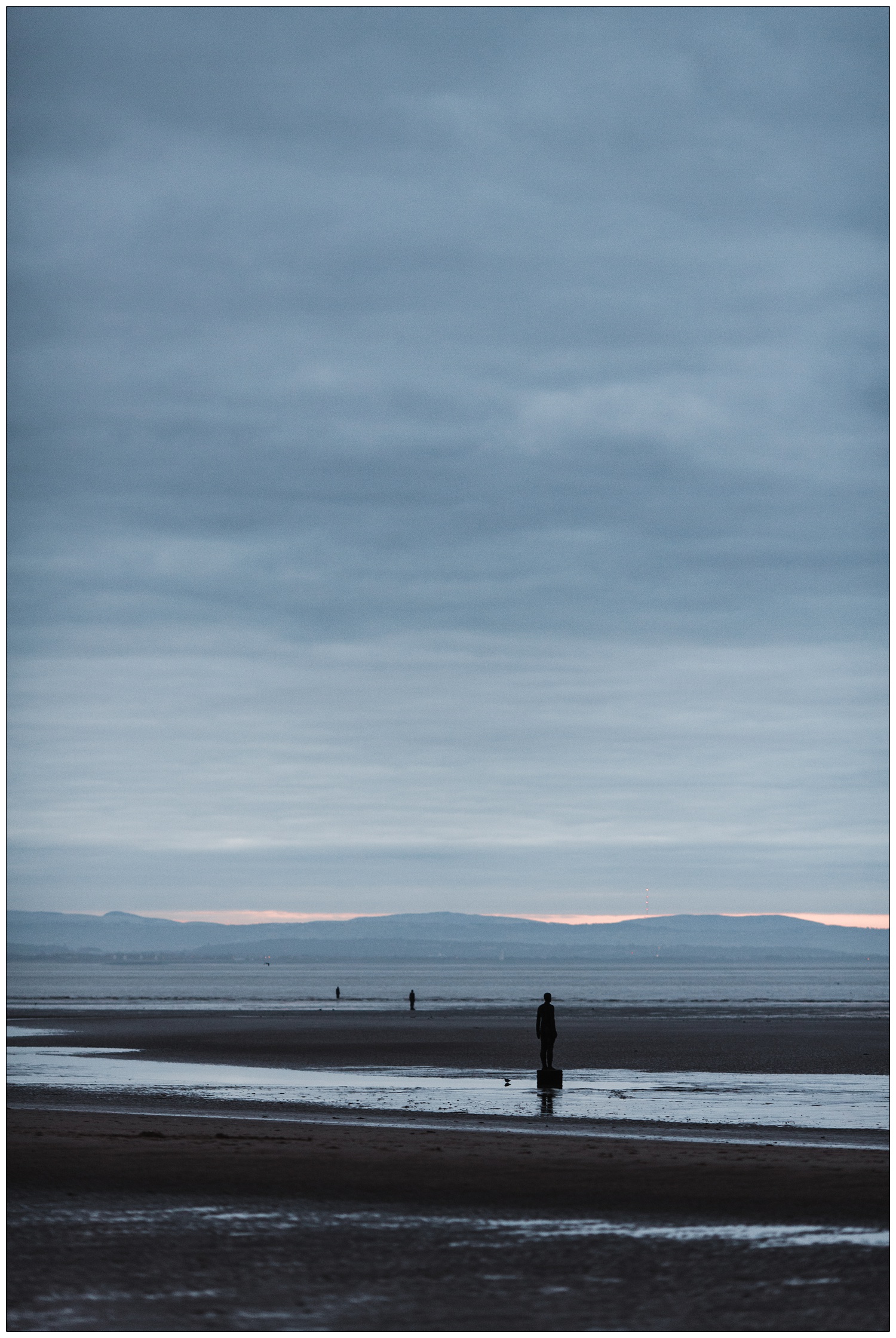 Another Place by Antony Gormley on Crosby beach at twilight