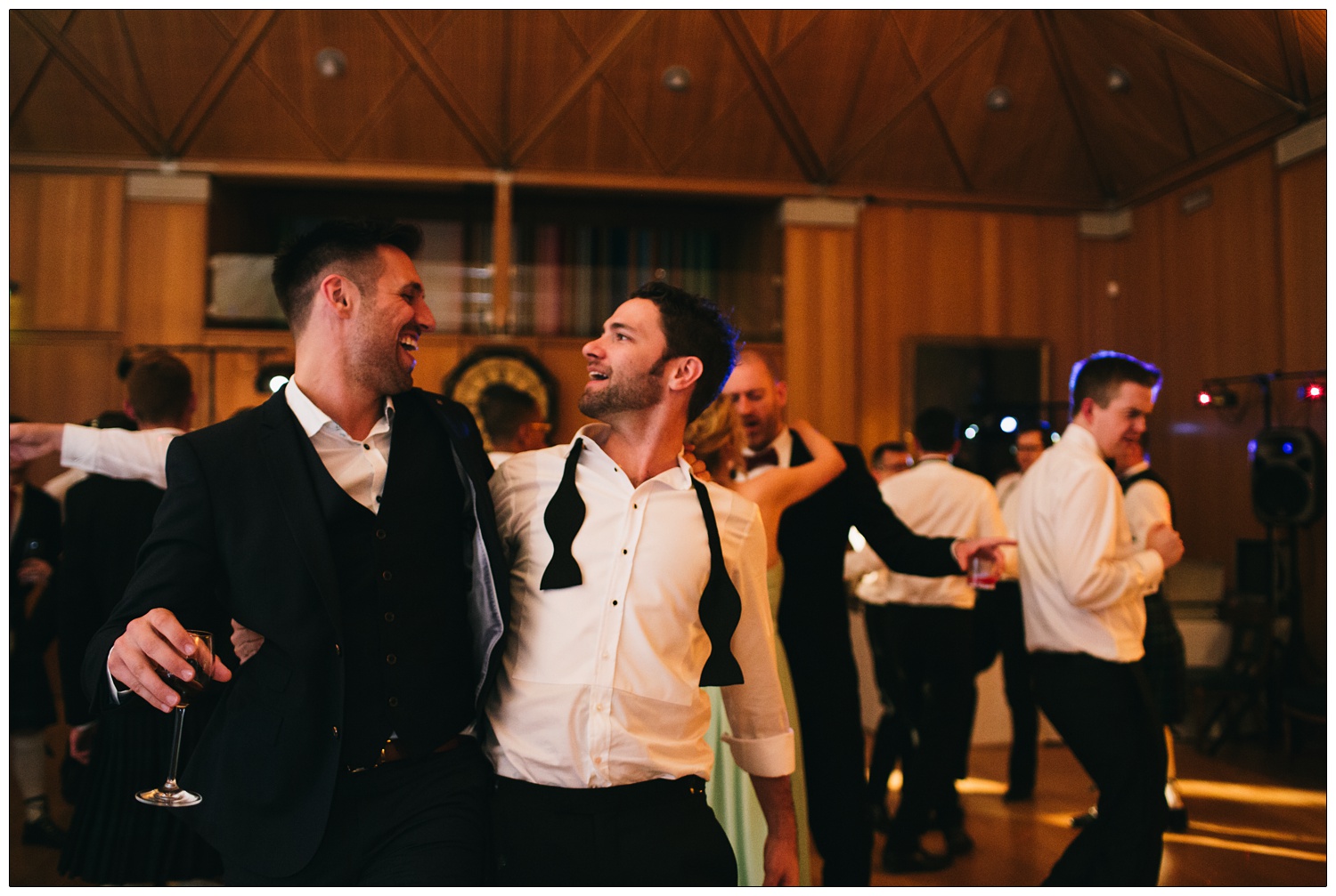 Two men dancing together. One has a bow tie undone.