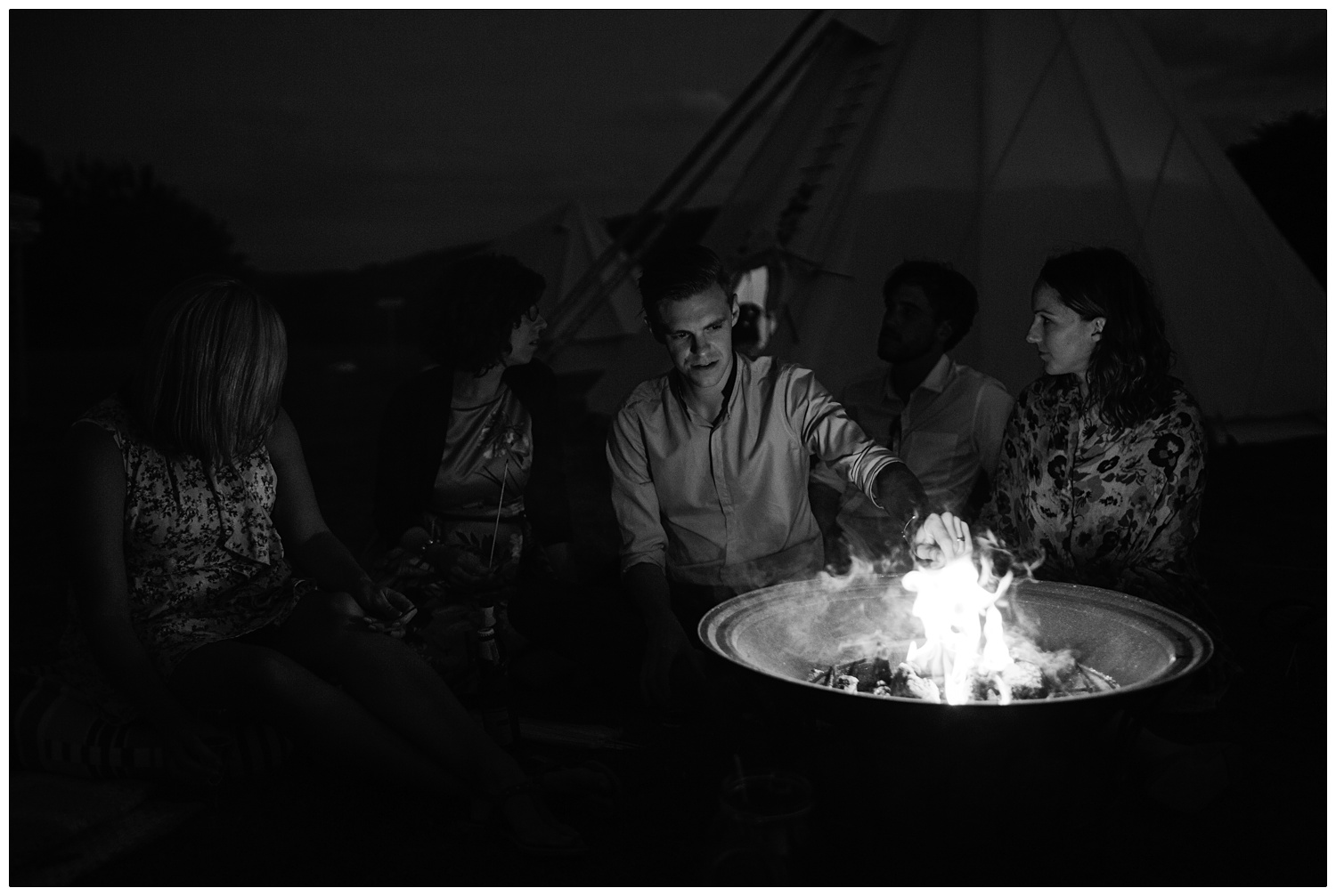 A man toasting a marshmallow on a firepit.