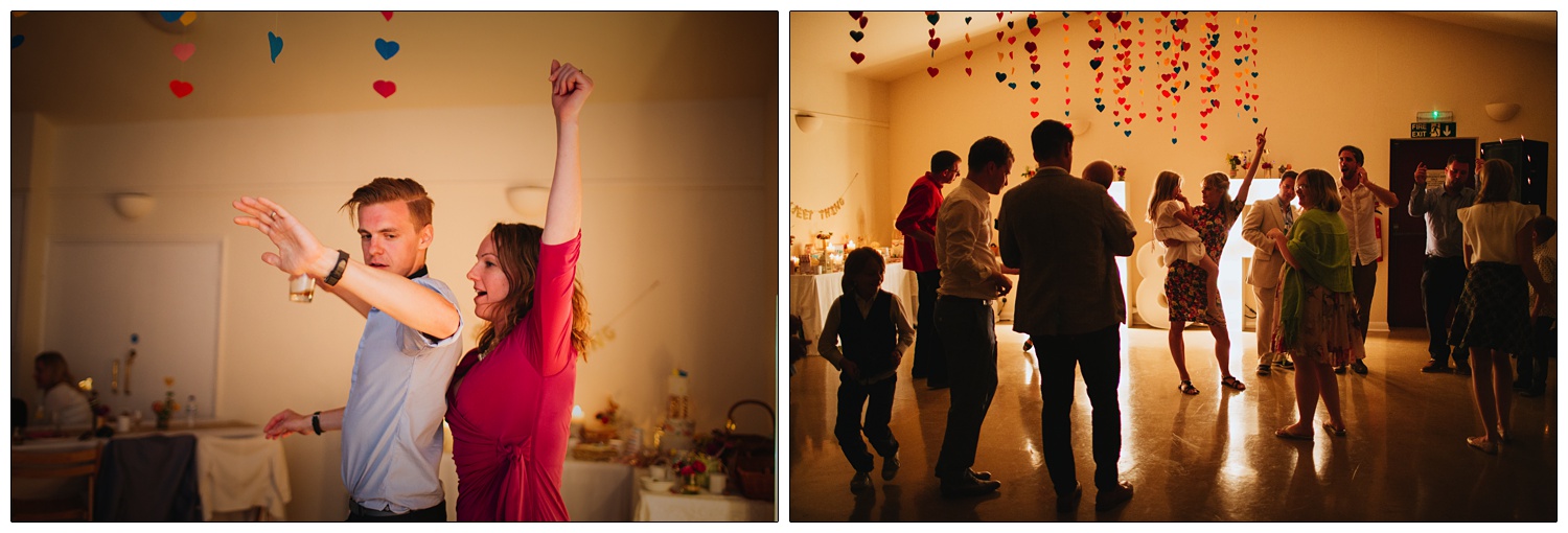 A woman holding a girl has her arm in the air at a wedding reception in front of illuminated letters.