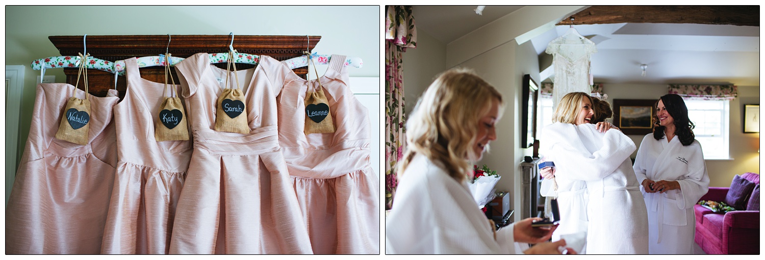 Pink bridesmaids dresses hang up on a wardrobe.