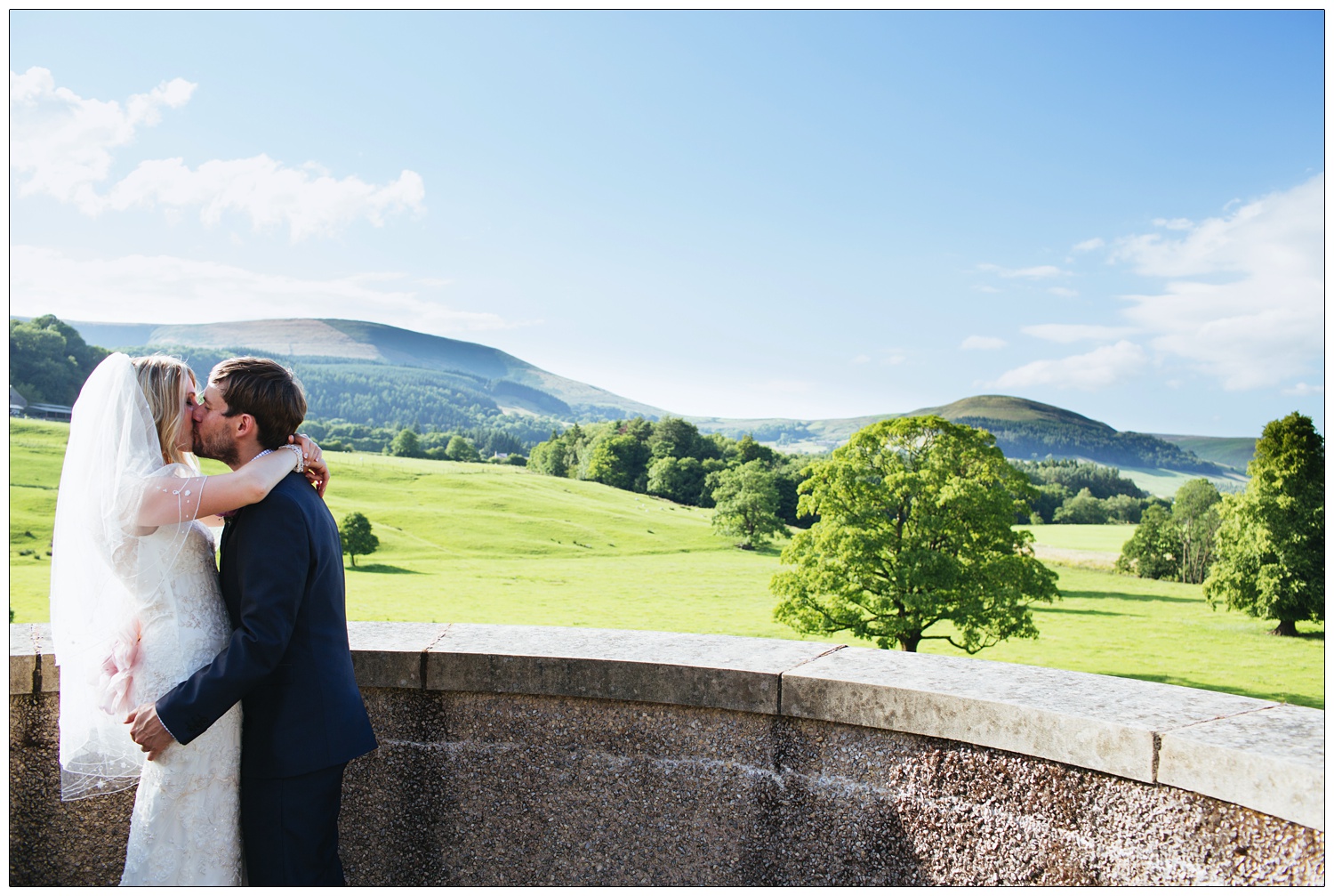 At the top of the Inn at Whitewell a couple kiss with the countryside in the distance.