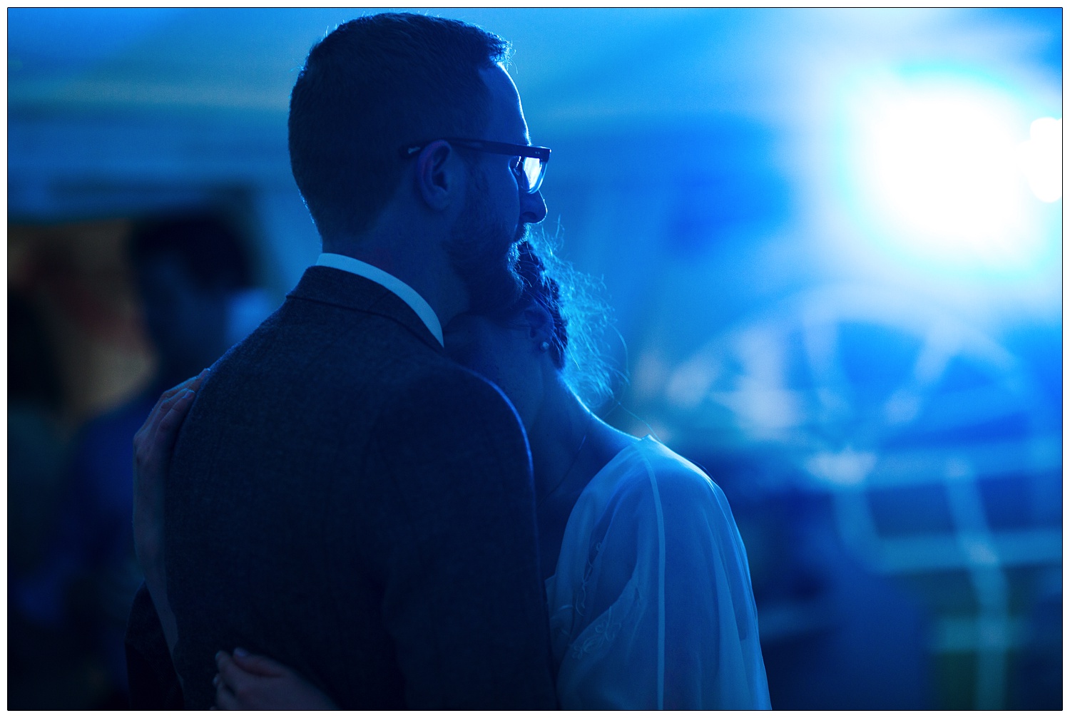 Bride and groom having their first dance in blue light.