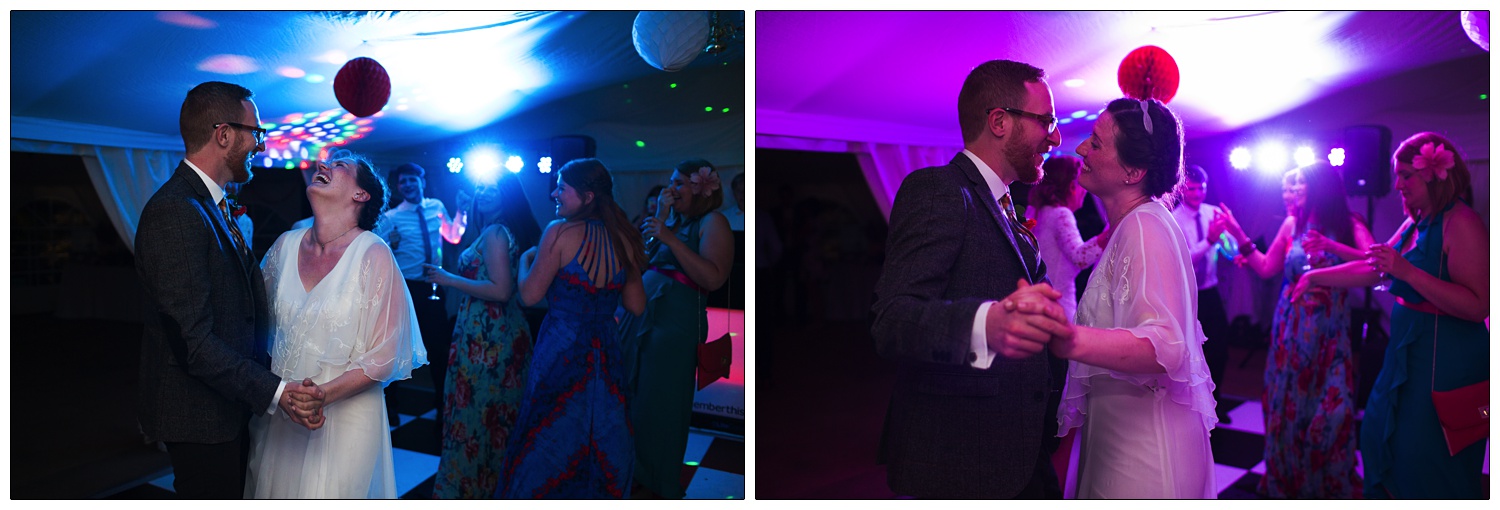 Bride and groom dance under blue and purple lights.