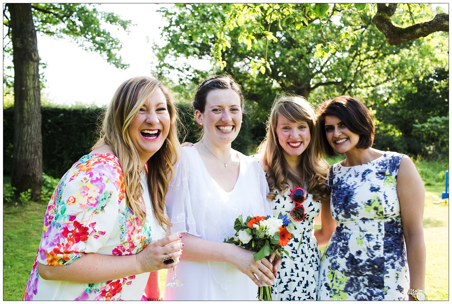 The bride with her friends are smiling.