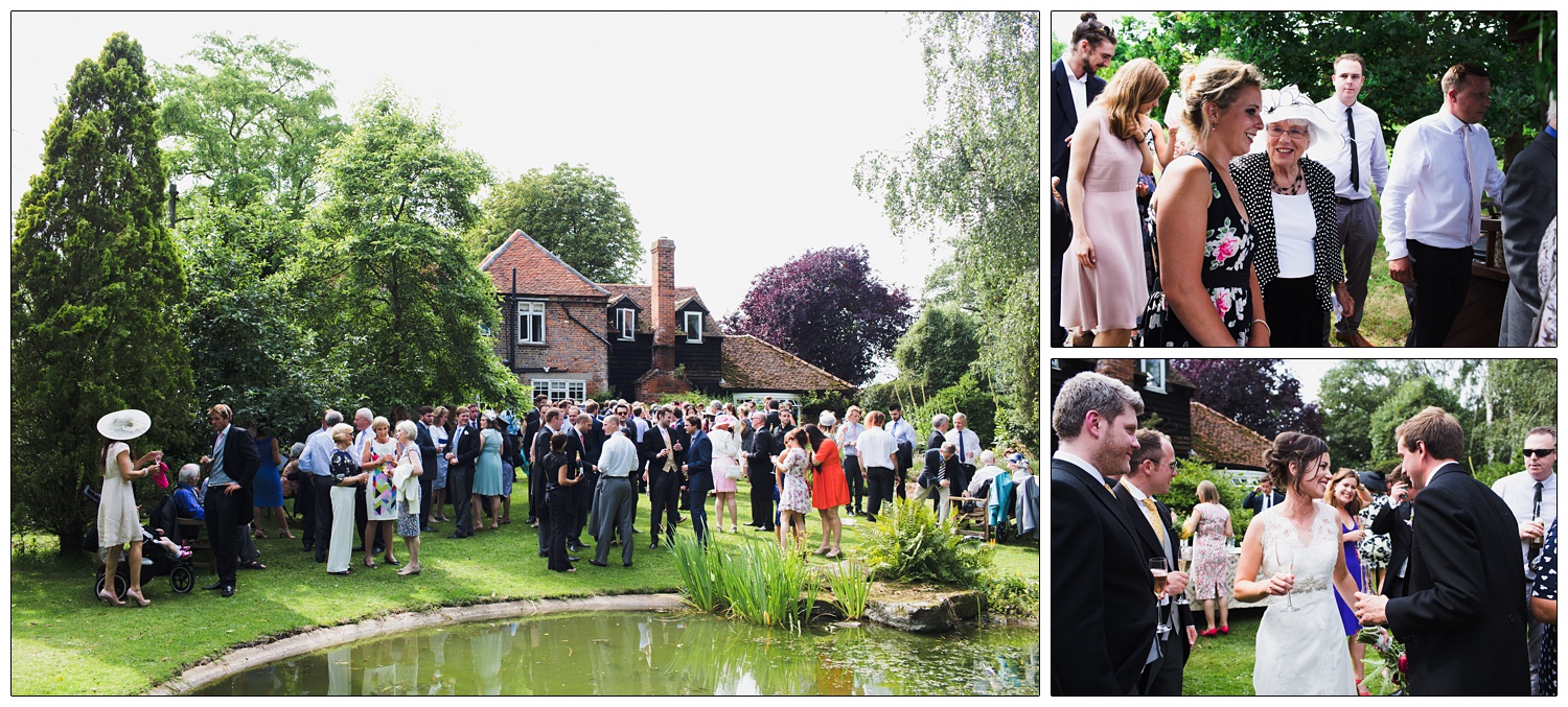 Wedding guests in the garden of the family home, there is a pond and trees.