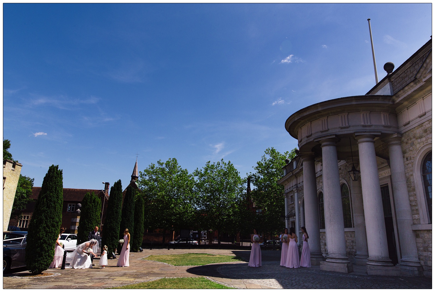 A view of the bride and bridesmaids arriving at Brentwood Cathedral. The sky is blue.