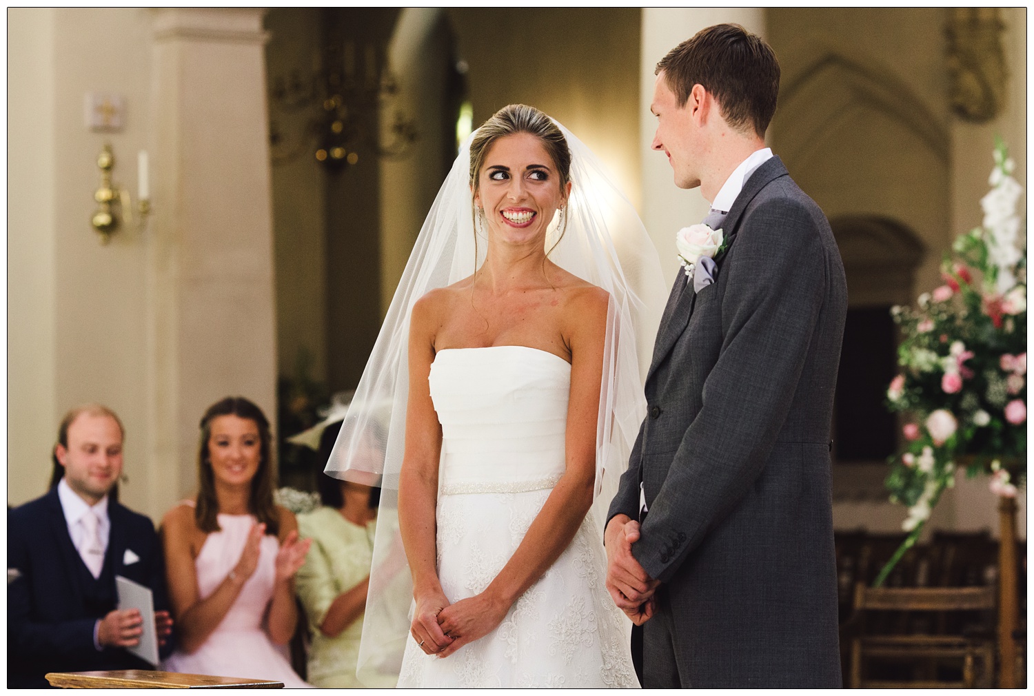 A woman in her wedding dress smiles at the man she is marrying in Brentwood Cathedral.