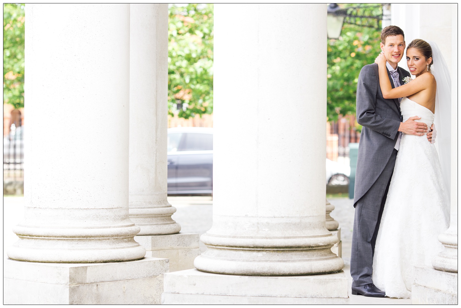 Newly married couple pose by the pillars at Brentwood Cathedral.