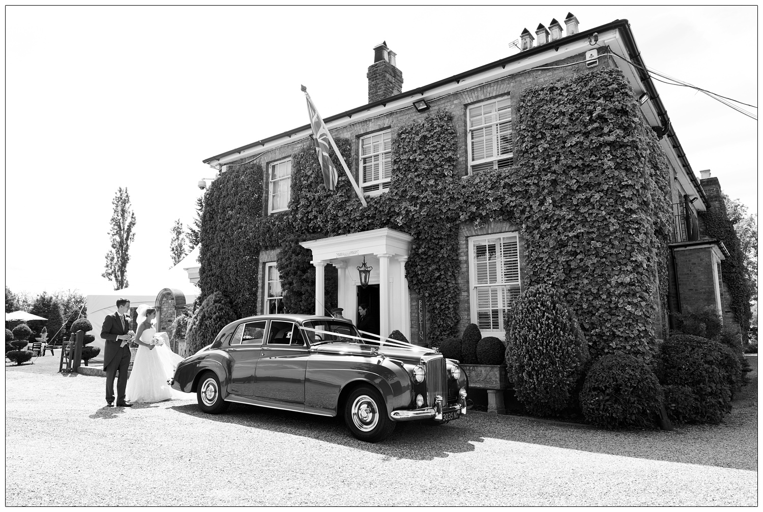 Bride and groom with the car outside Friern Manor.