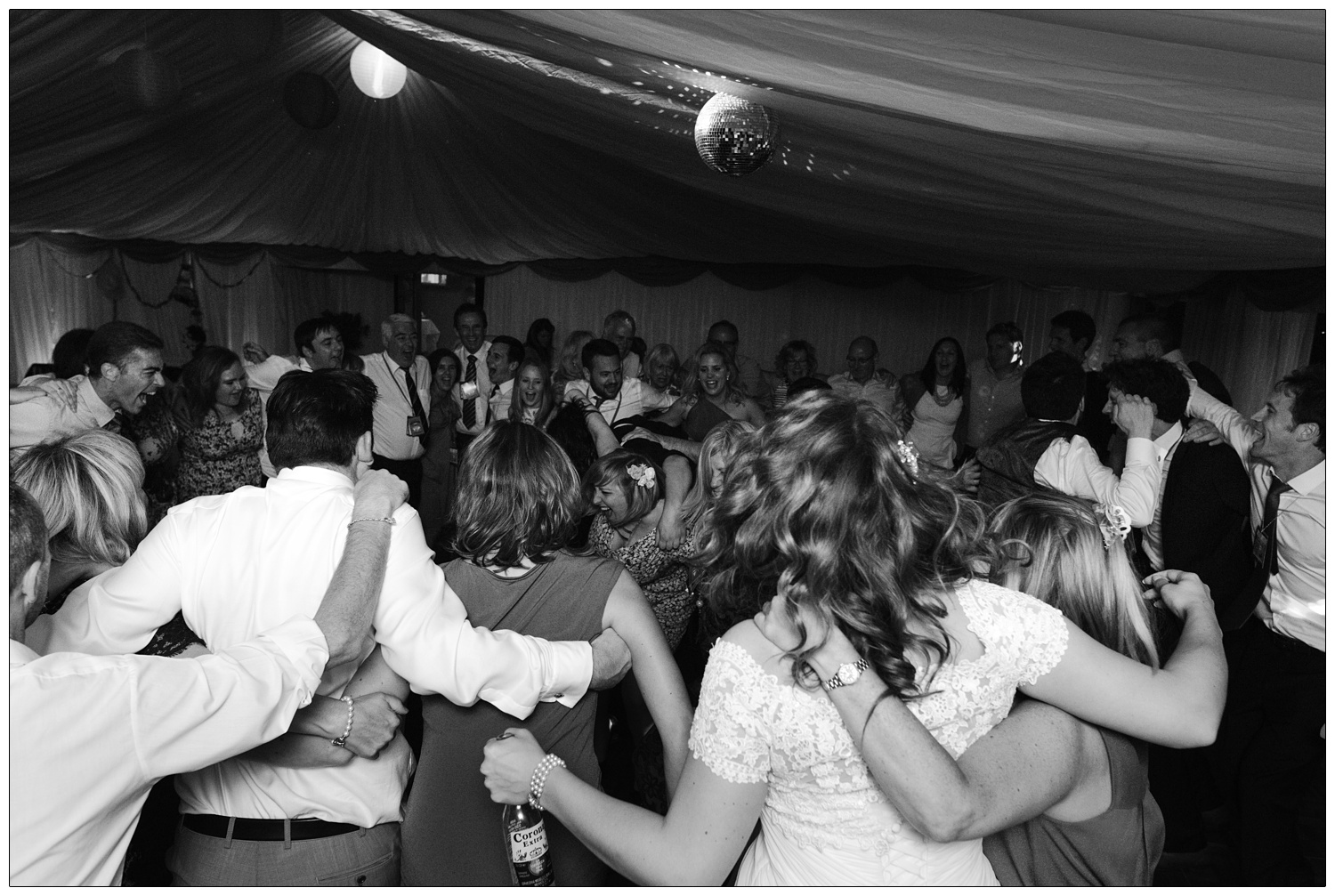 A marquee full of people dancing in a circle.