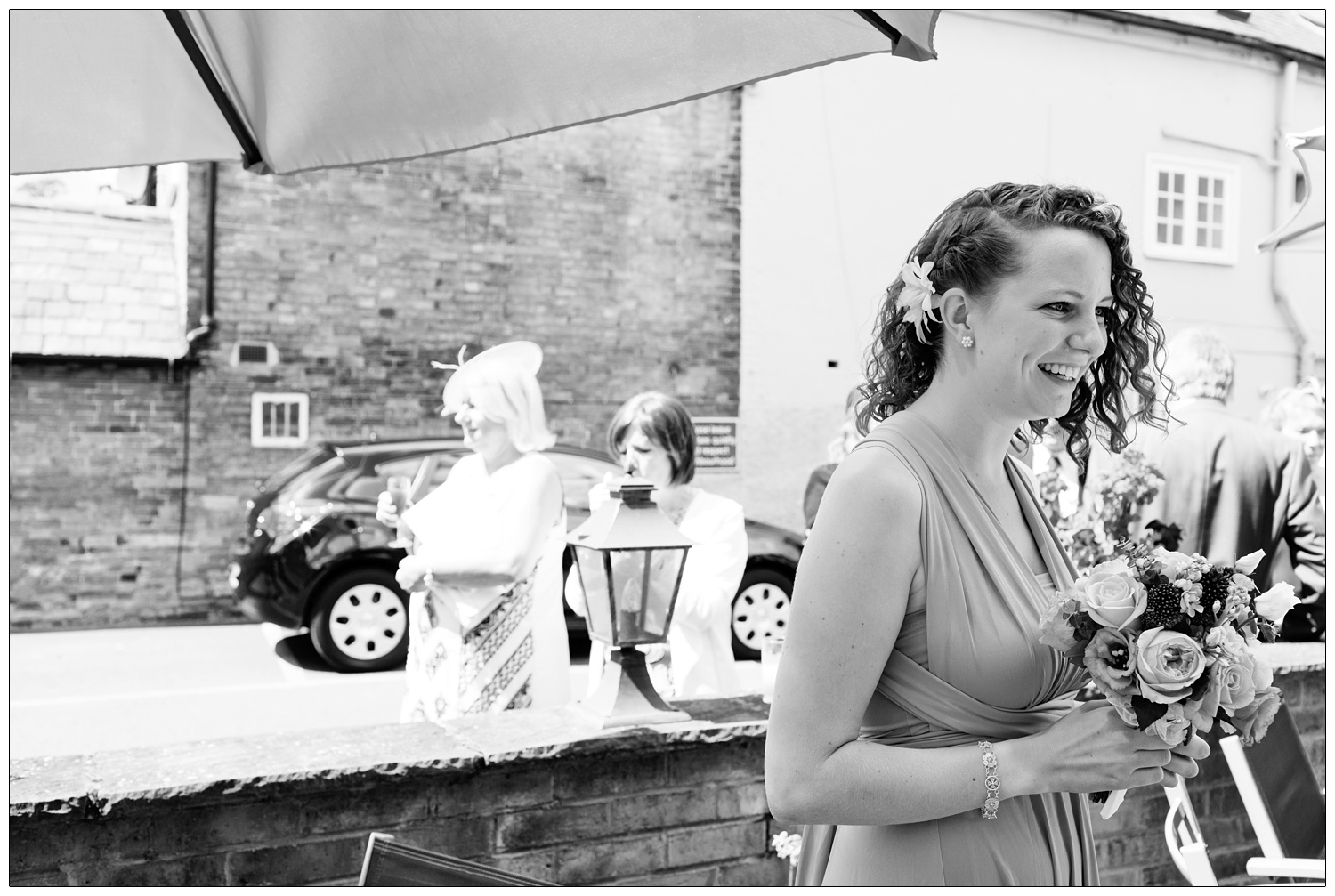 Candid black and white photograph of a bridesmaid.