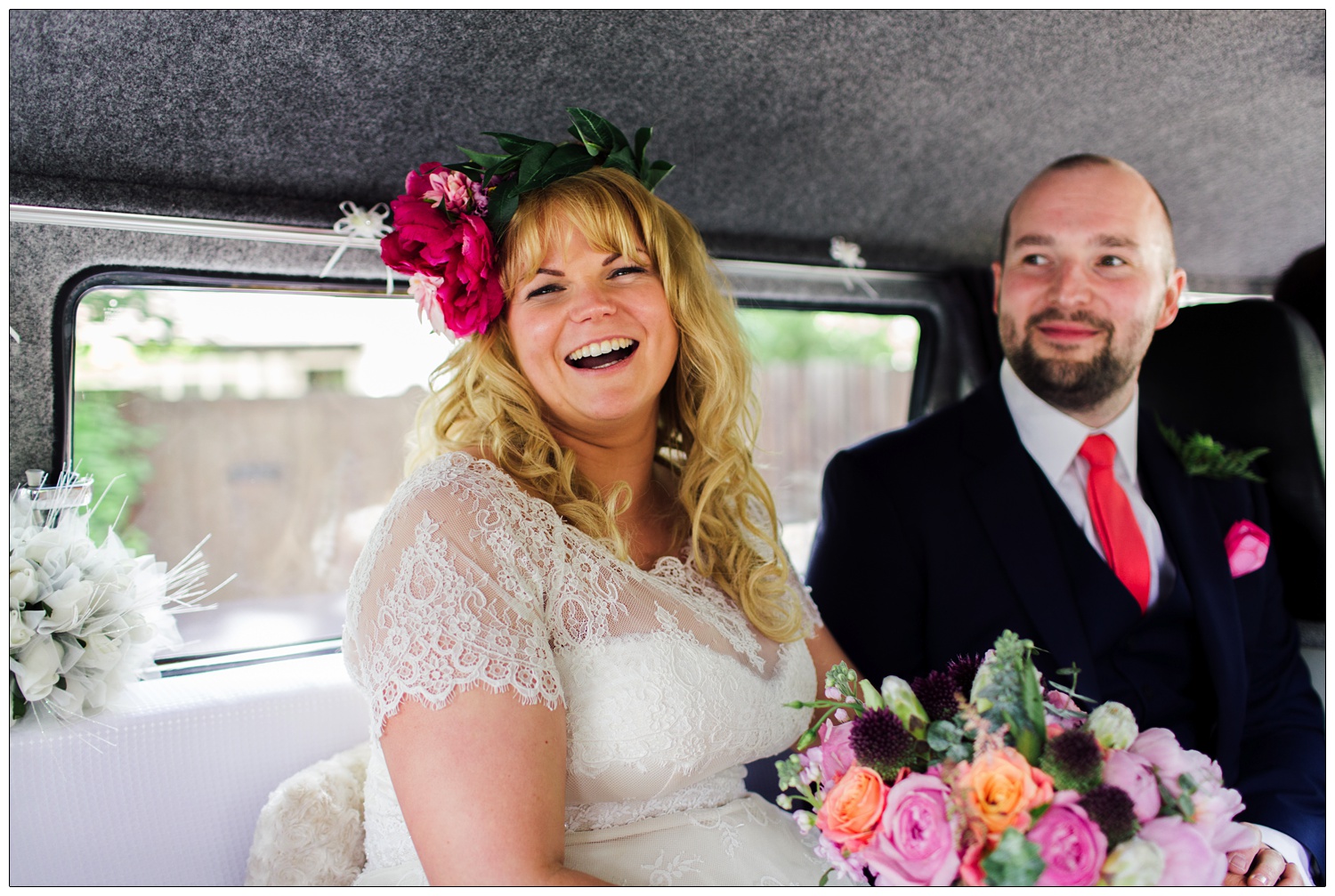 Bride is laughing at the camera in a camper van.