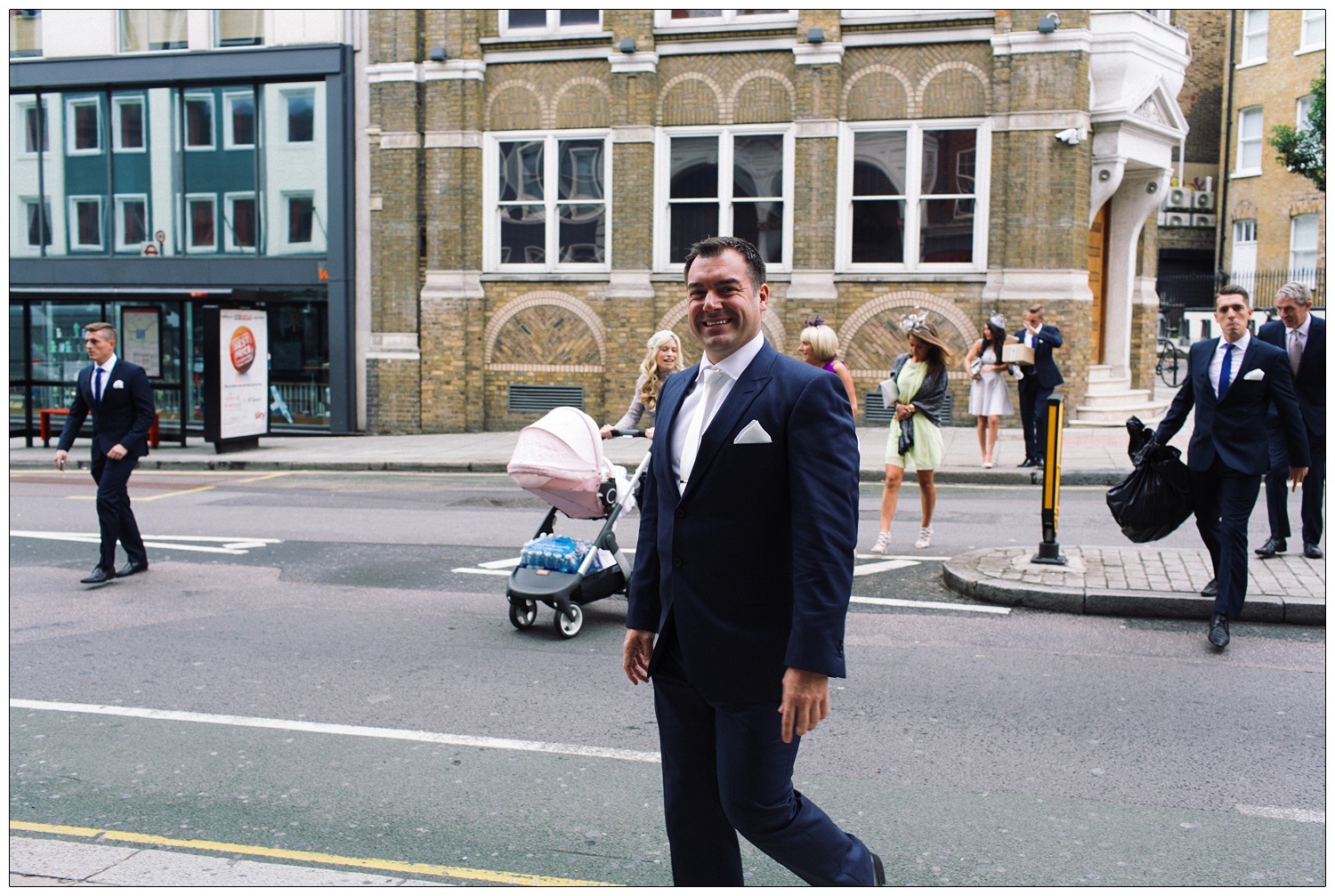 Man and friends crossing Clerkenwell Road to the church for the wedding.