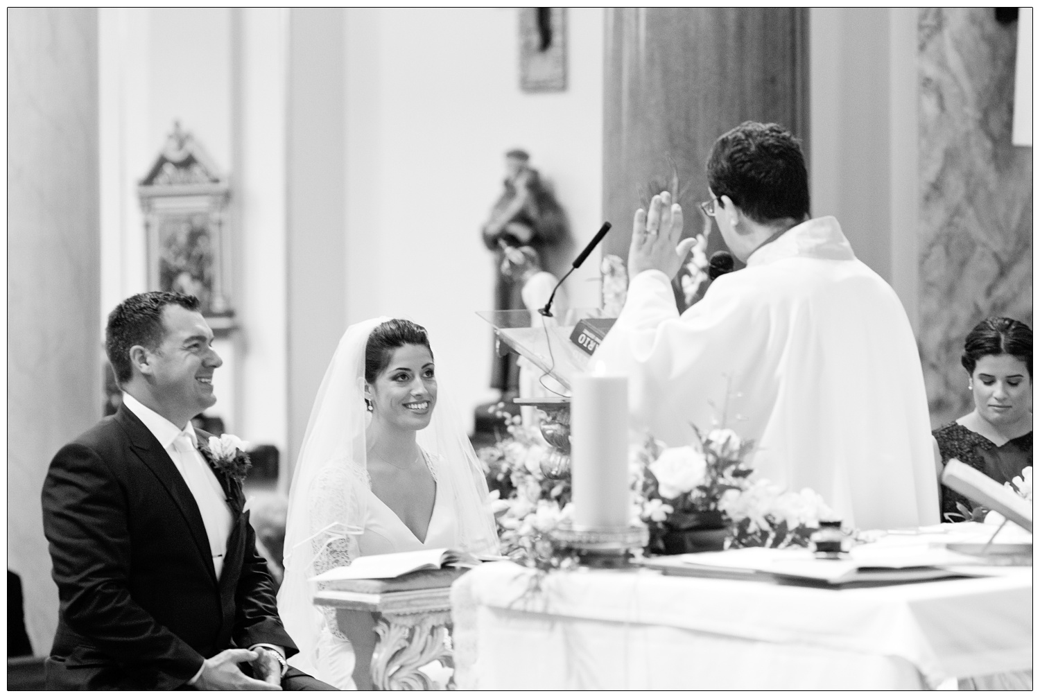 Groom and bride are sat down during a wedding.