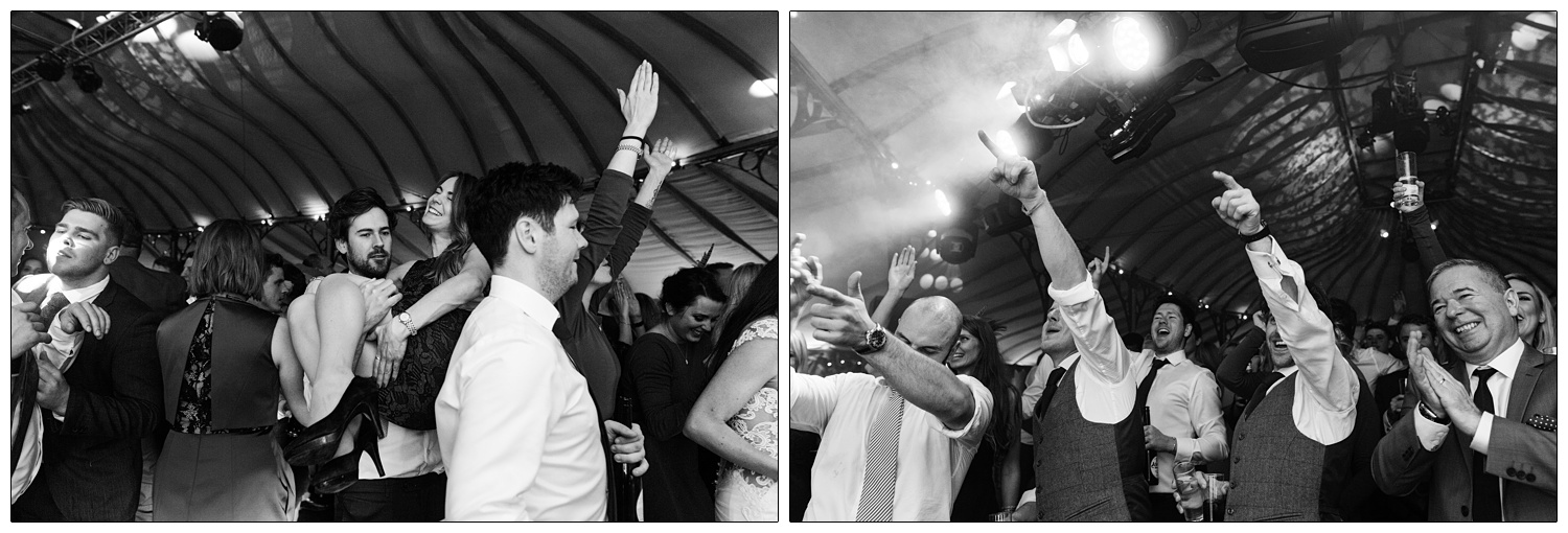 Men pointing their fingers up in the air at the band performing.