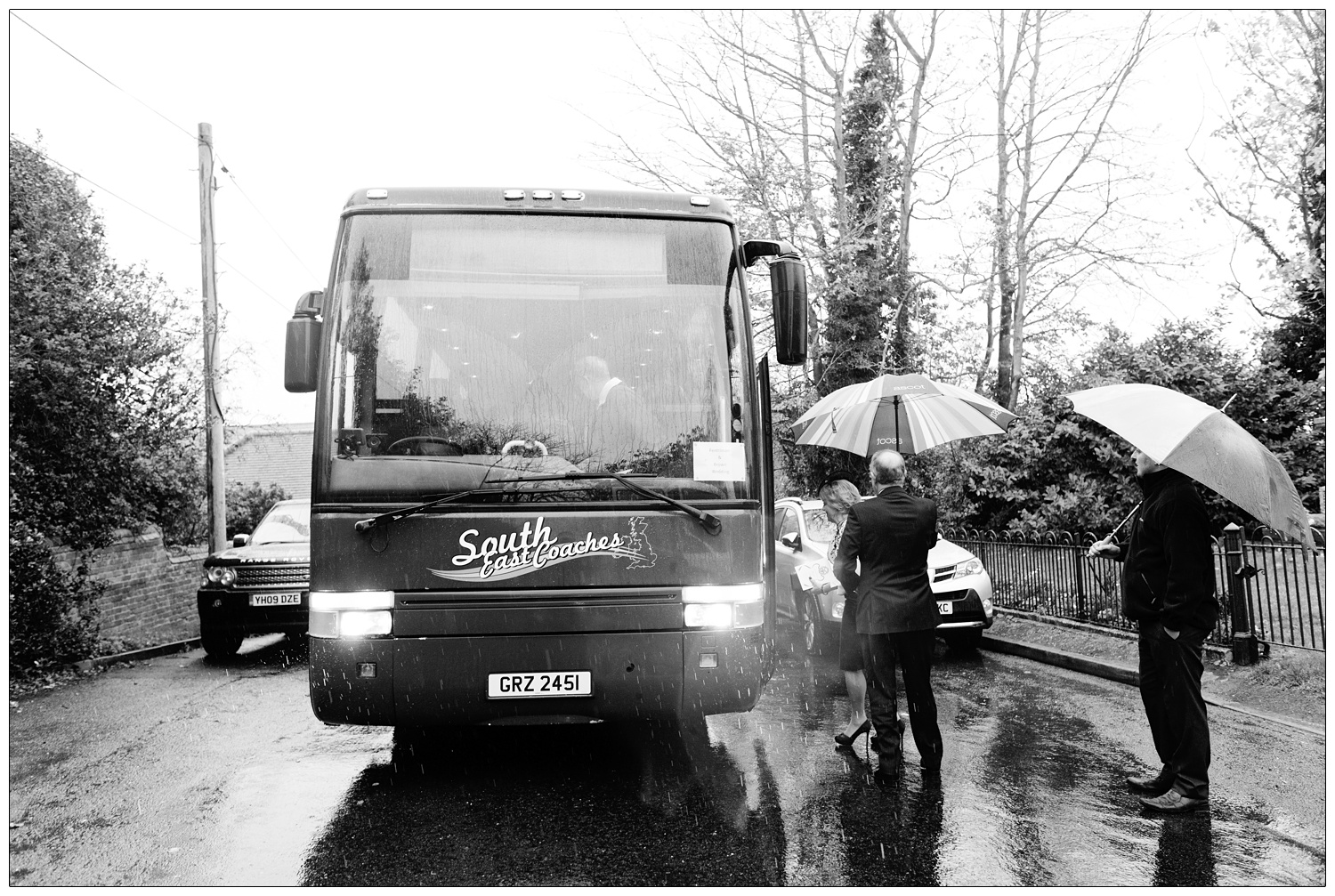 People queing up to board a coach in the rain in Purleigh.