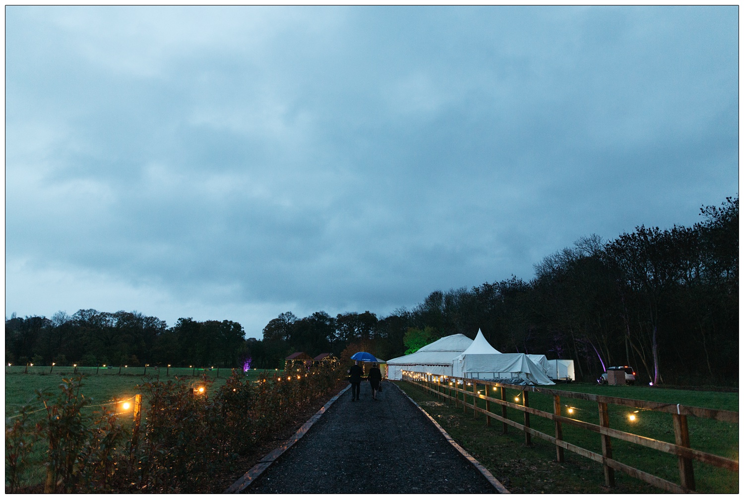 The path to the orangery style tent for a wedding. The sky is grey and it is windy.