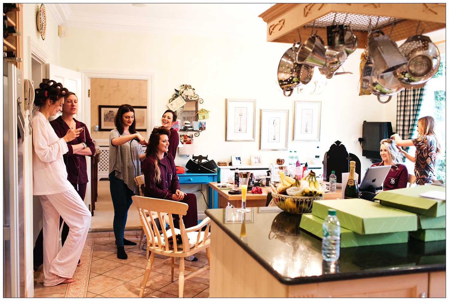 The bride and her bridesmaids are in the kitchen on the morning of her wedding. They are all wearing pyjamas.