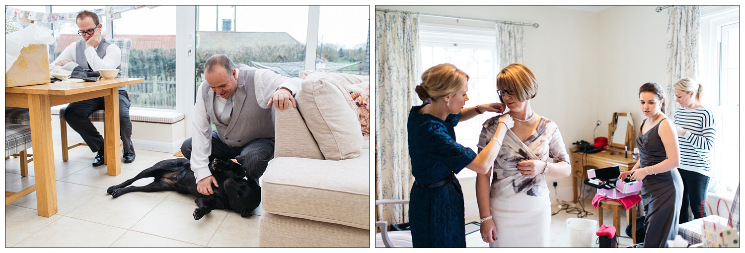 A man strokes the dog. A woman helps a the bride's mother with her dress.