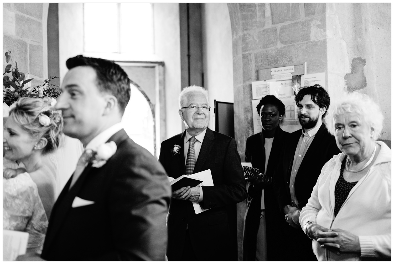 black and white photograph in Norfolk church of wedding guests