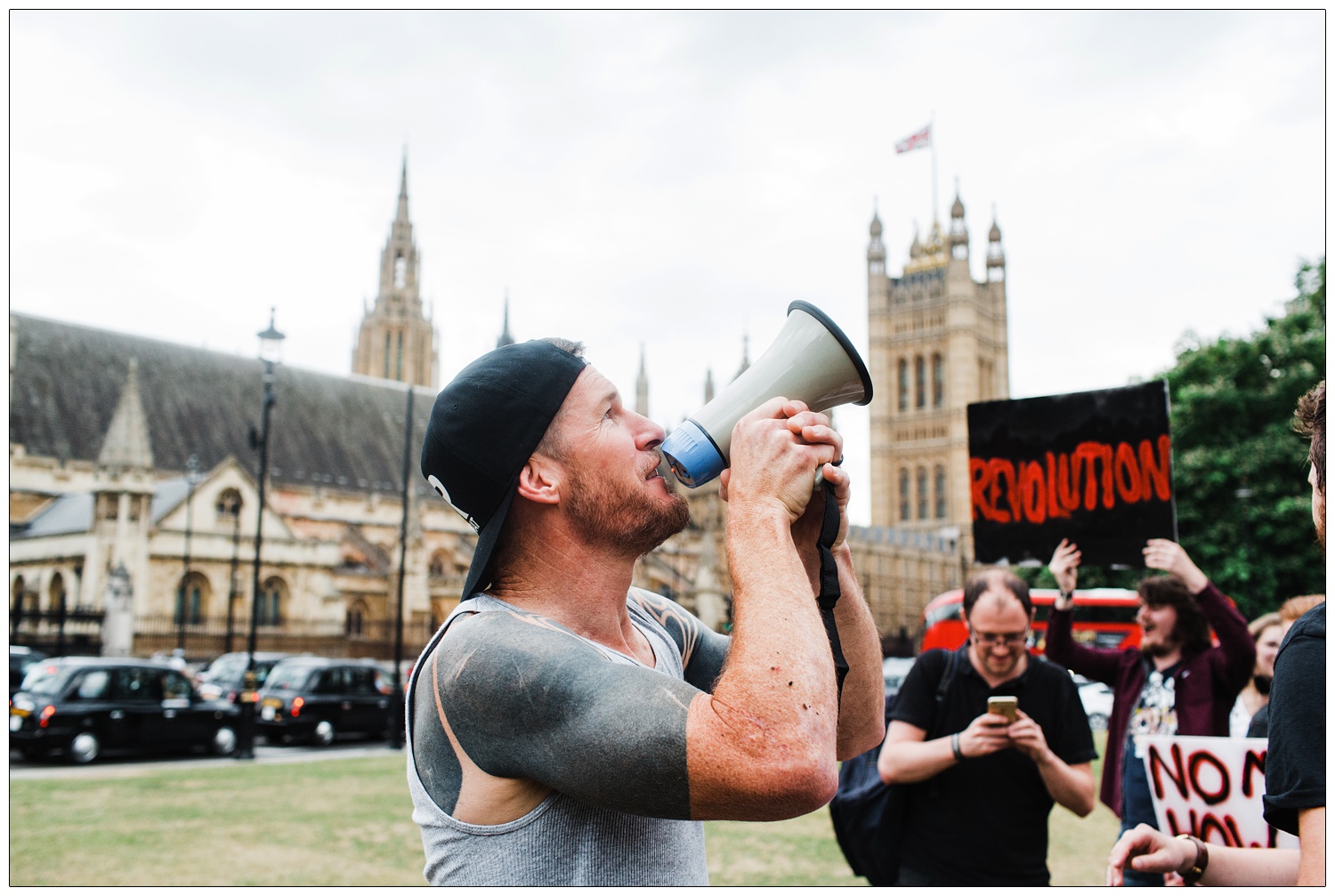 Tim Commerford in Parliament Square with protest signs shooting a Wakrat music video for Generation Fucked single