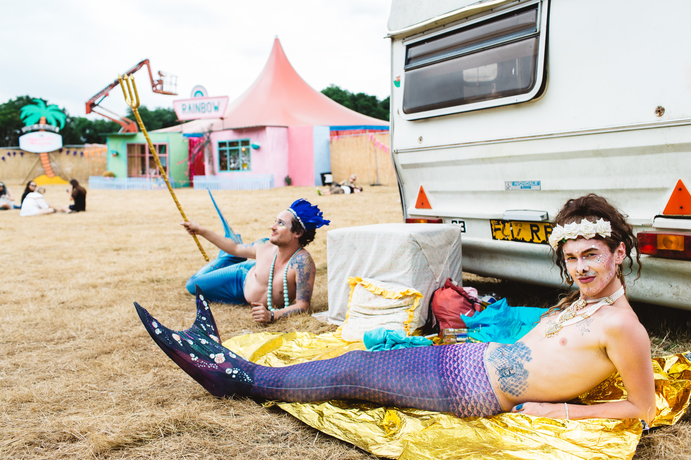 Charity Kase dressed as a mermaid lying by a caravan at Leefest Neverland.