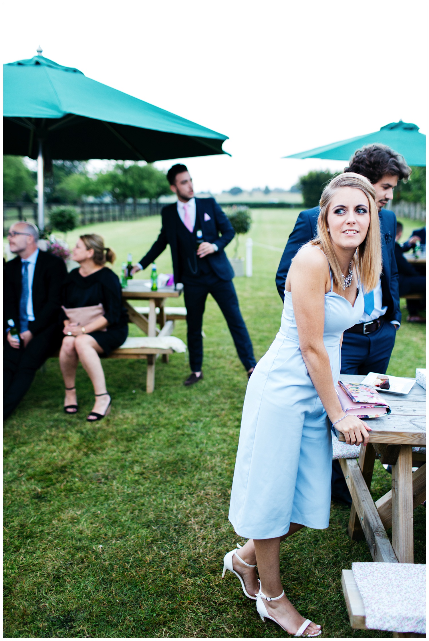 woman in a blue jumpsuit leaning on a picnic table