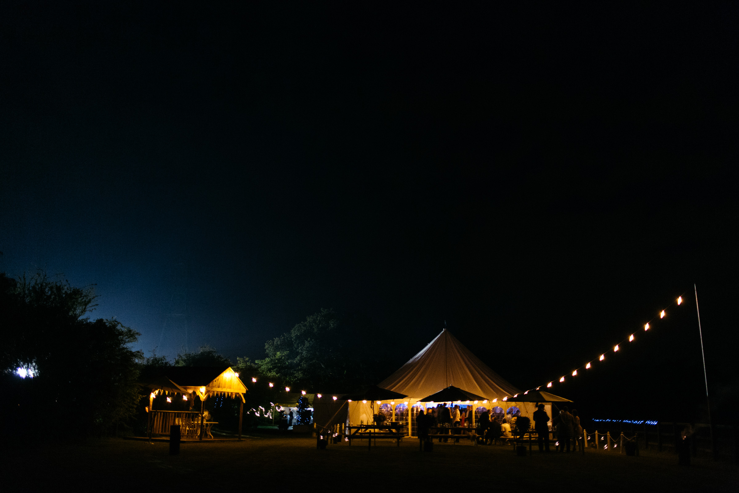 a wedding marquee lit up at night in a garden in Purleigh Essex