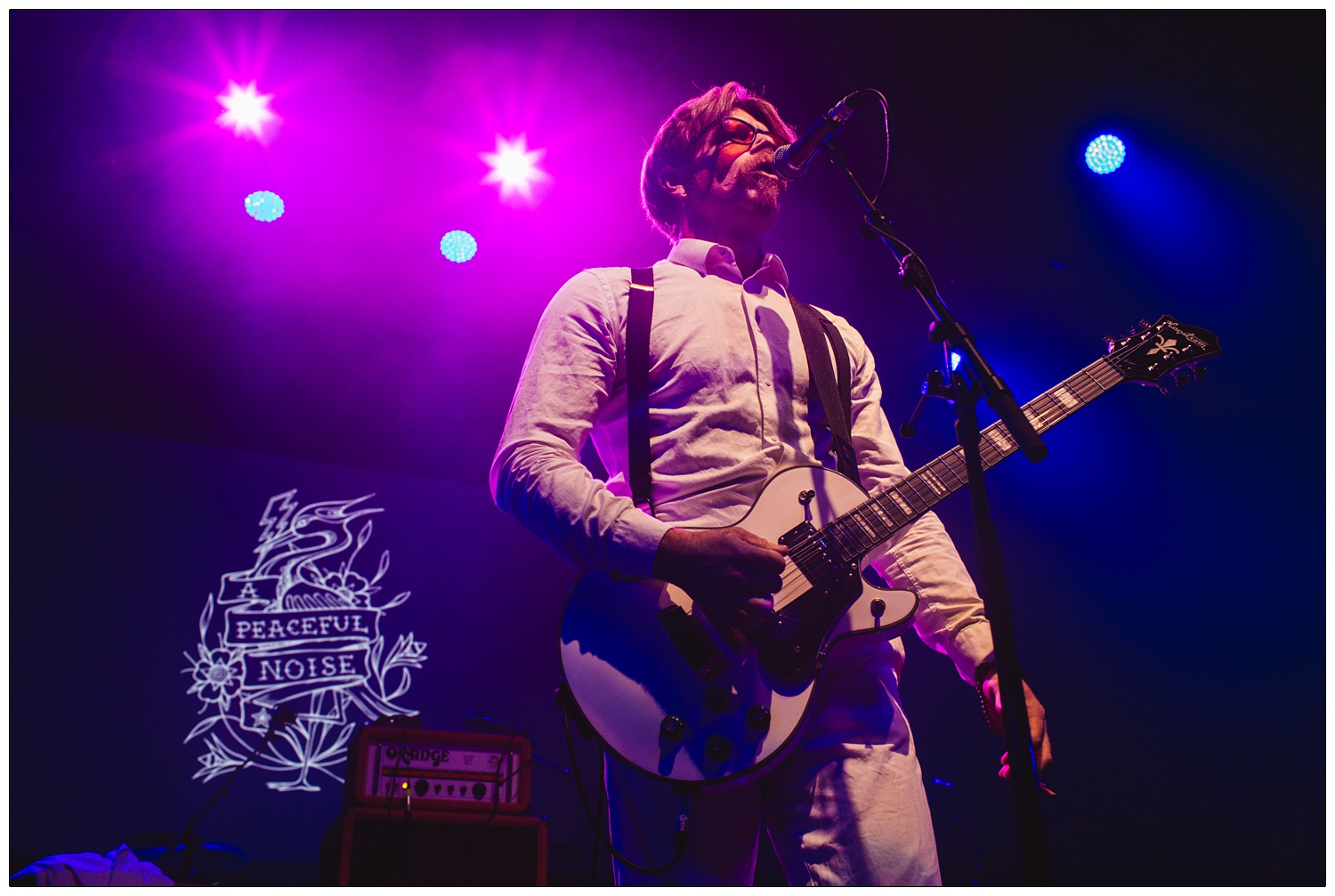 Jesse Hughes of Eagles of Death Metal under purple lights at A Peaceful Noise