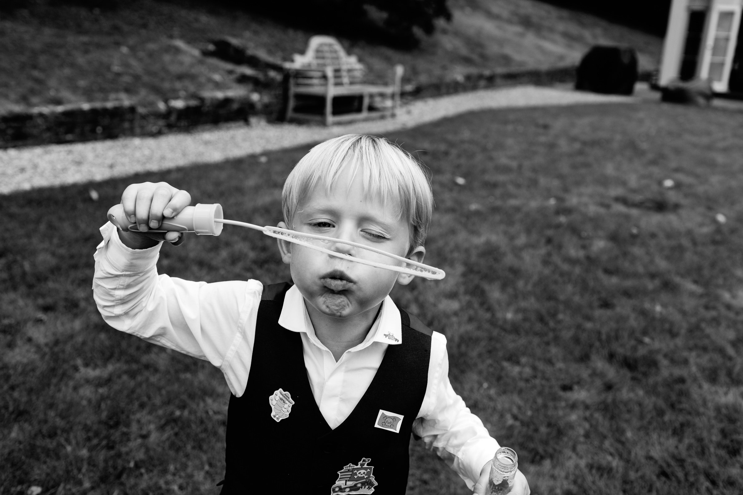 page boy blowing bubbles at a wedding at Maison Talbooth near Colchester