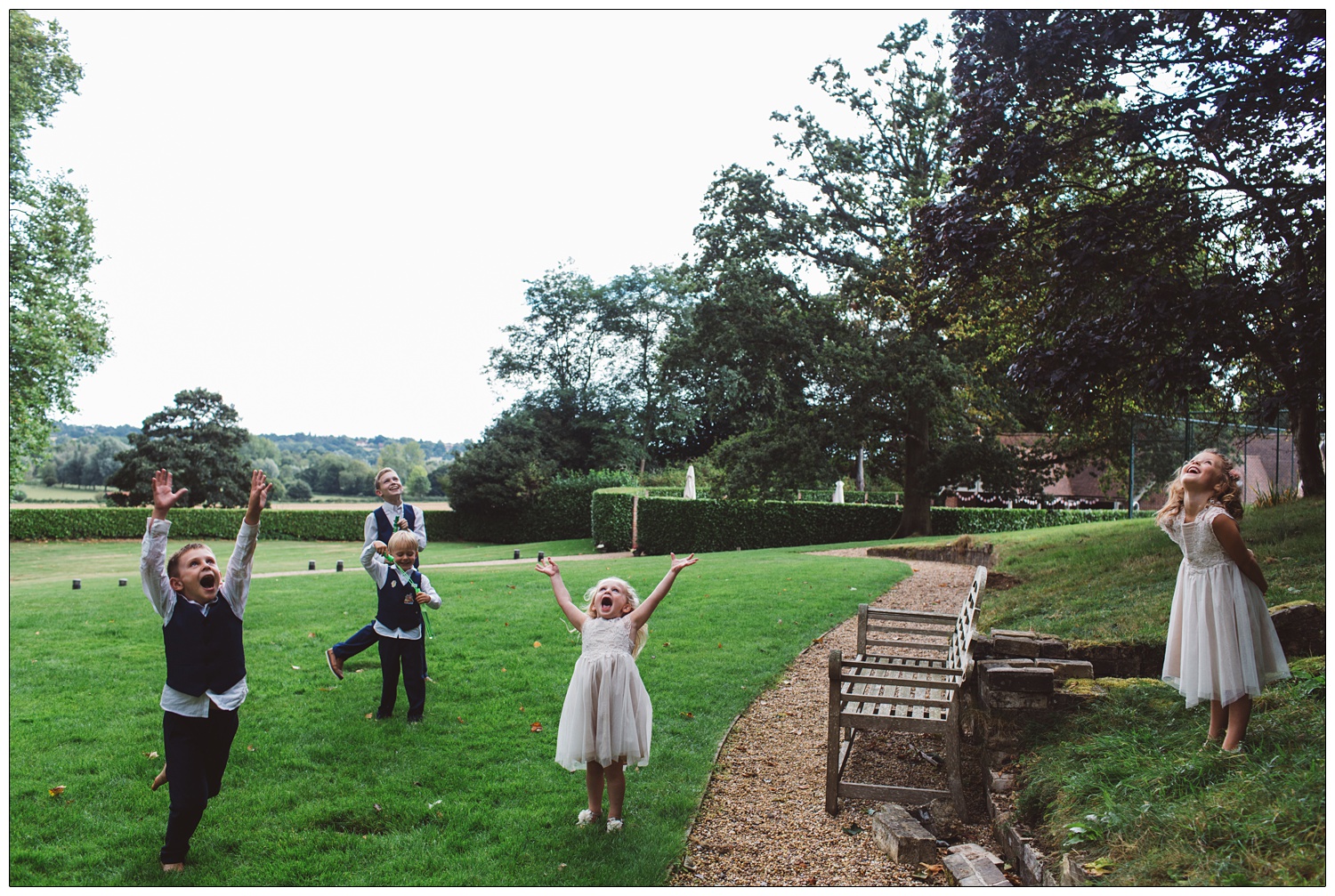 children looking up at the sky in the grounds of Maison Talbooth at a wedding
