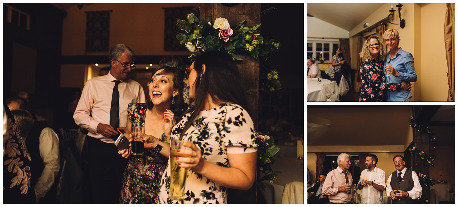 people drinking and talking and a couple hug at a wedding reception in the evening at The White Hart in Great Yeldham