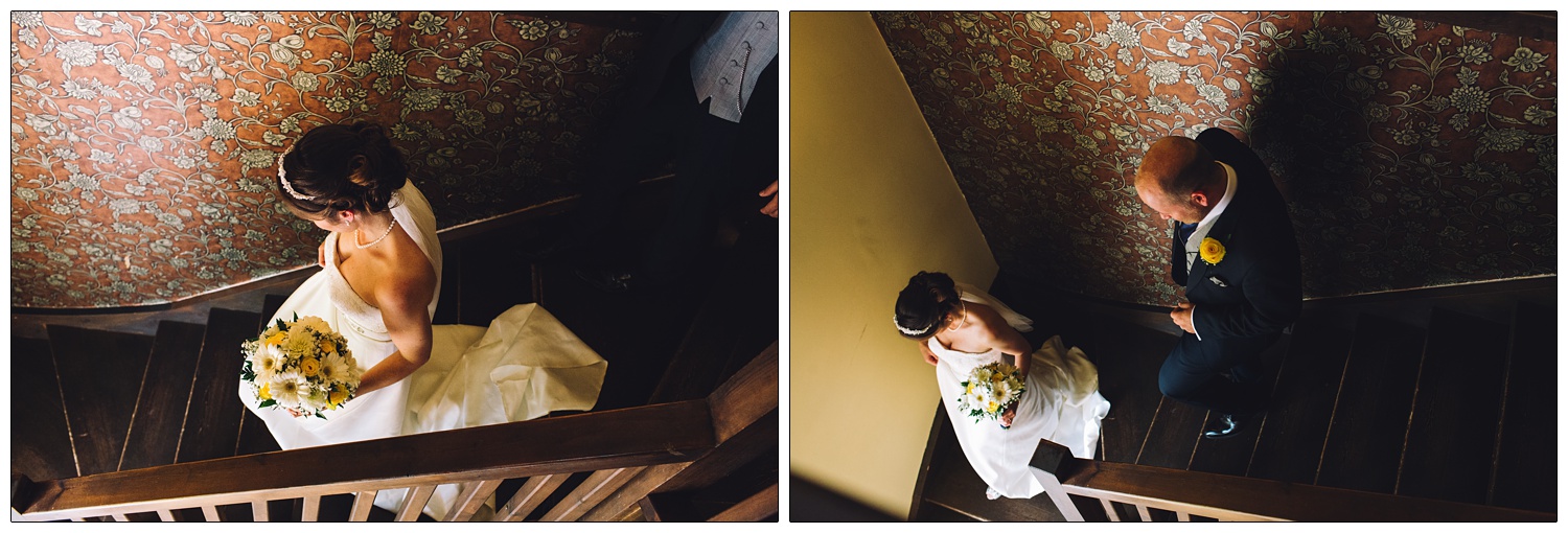 woman in a wedding dress and man in a suit walk down the stairs after wedding ceremony