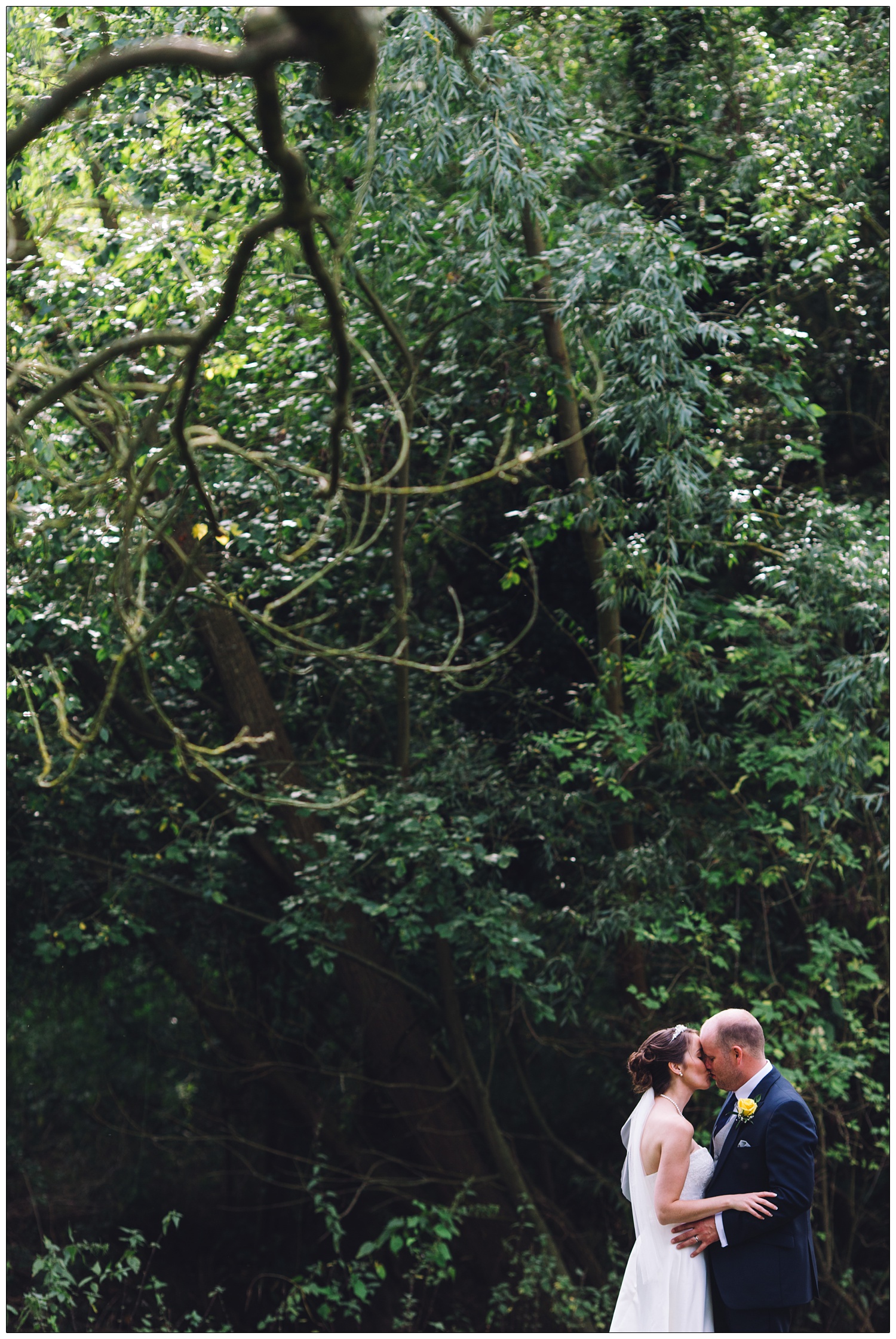 Bride and groom kissing in the gardens of The White Hart in Great Yeldham