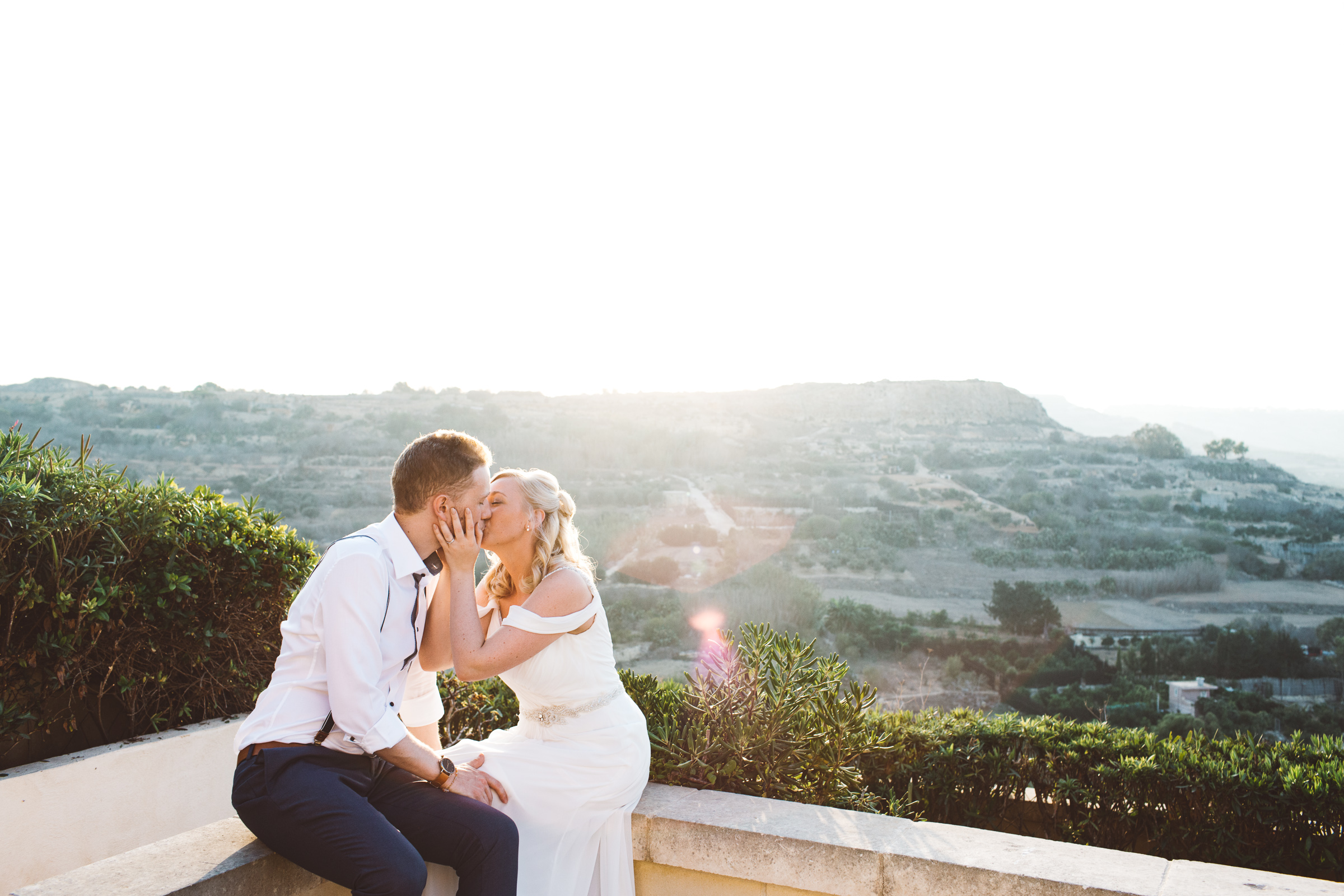 Bride and groom kissing at the Cornucopia Hotel in Gozo after getting married.