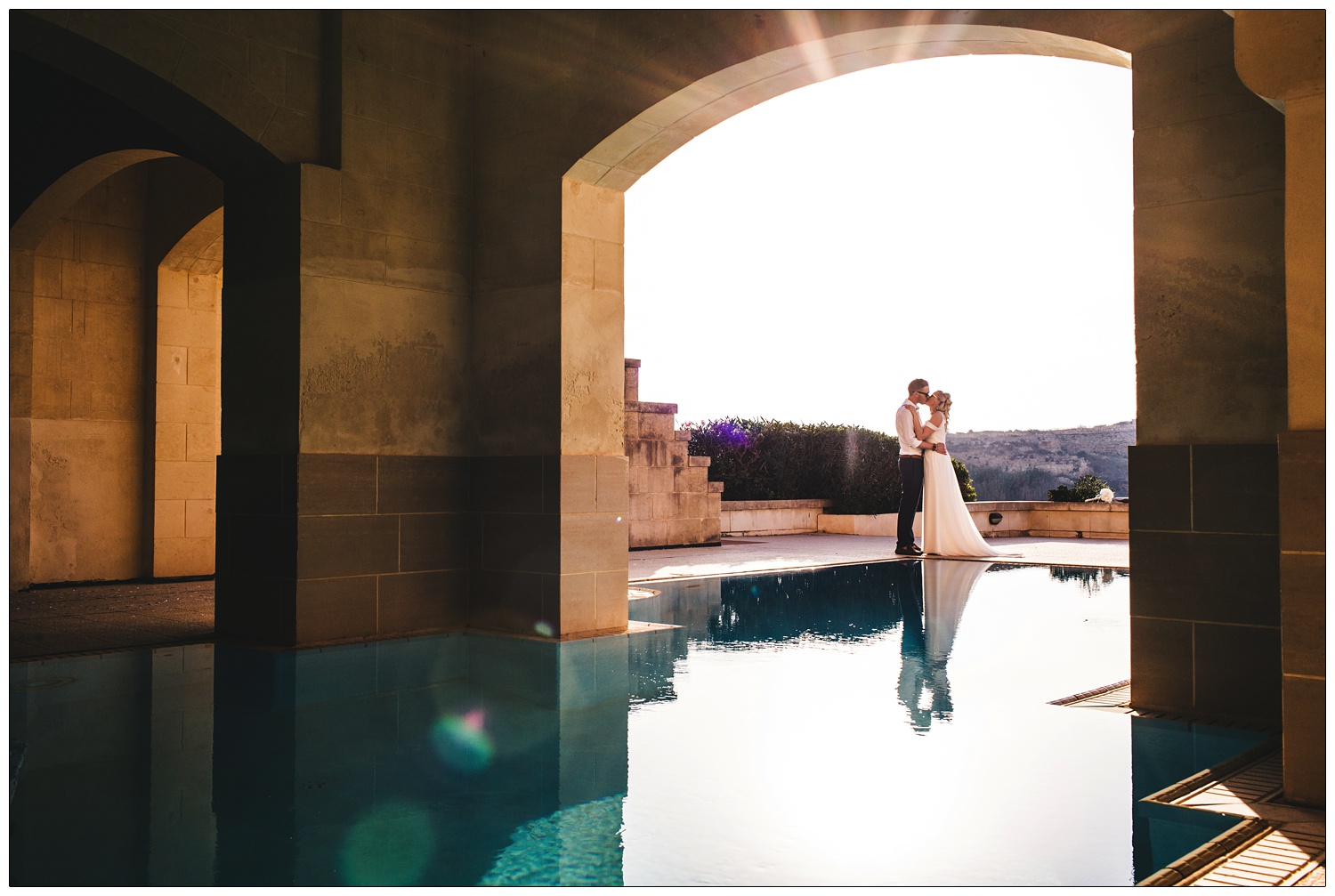 Couple kissing by the pool in the sunshine after a wedding ceremony at The Cornucopia Hotel