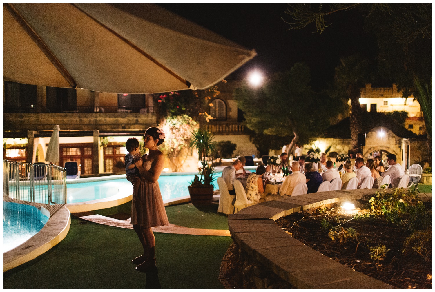 bridesmaid holding her child while wedding guests eat at The Cornucopia Hotel