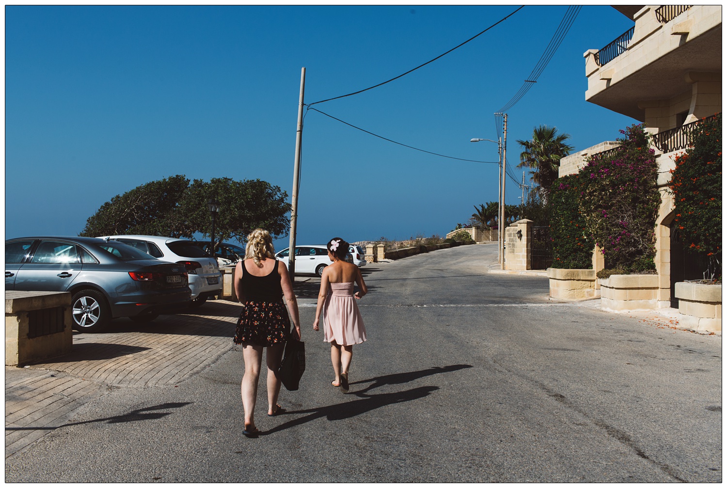 bride and maid of honour walking across the road in blue skies when getting ready