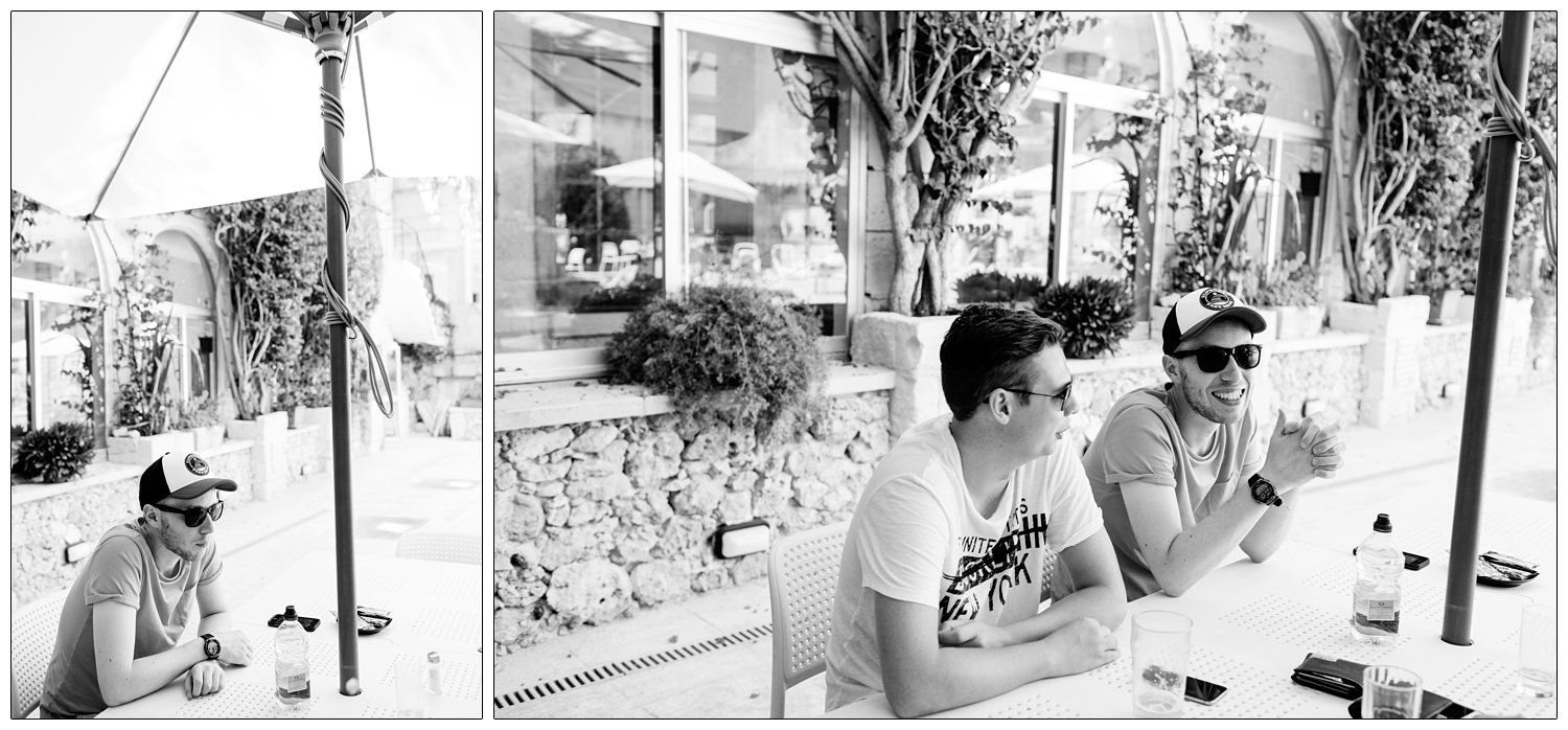 Groom with friends on wedding morning sitting at a table outside.