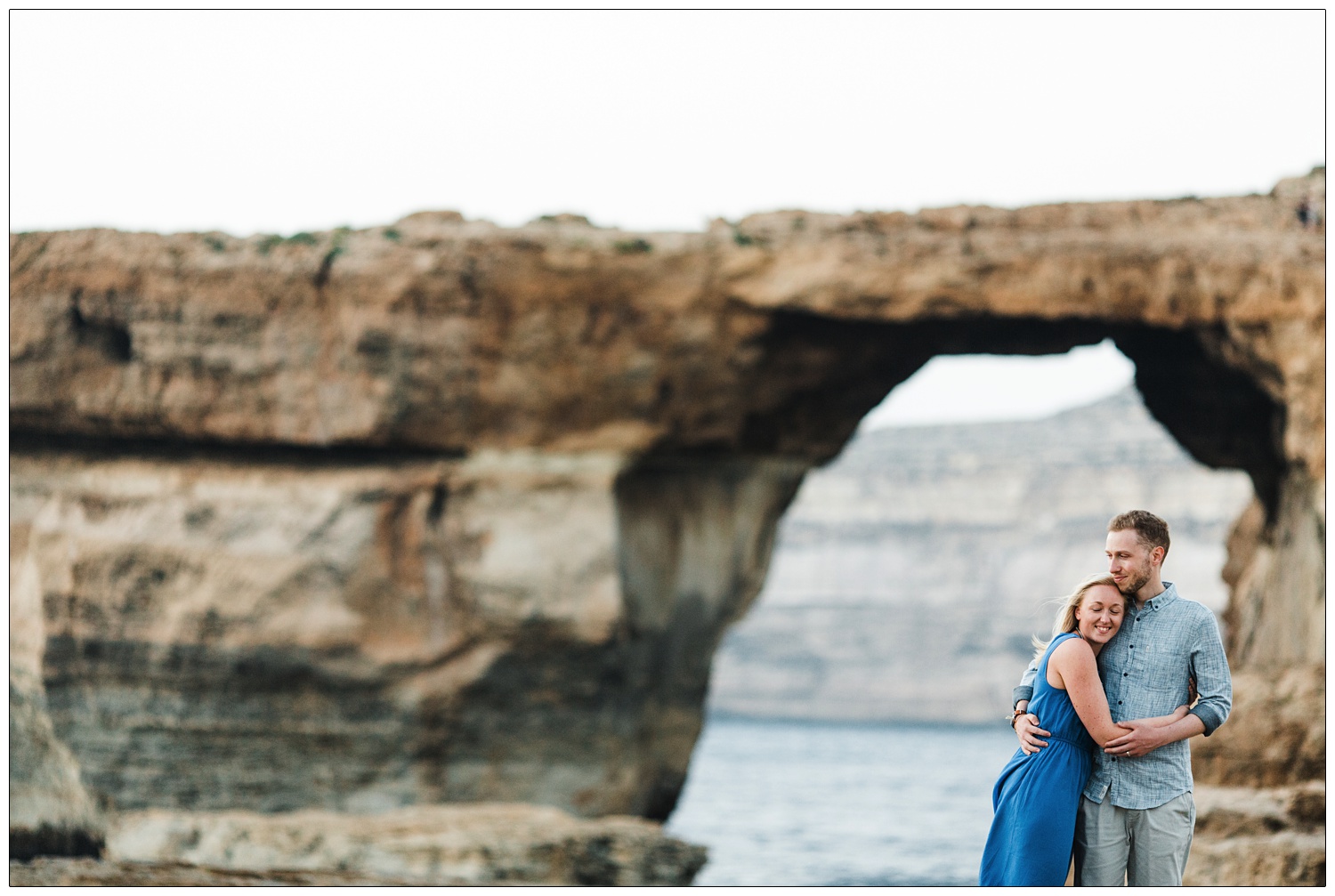 new husband and wife hug in front of the Azure Window in Gozo, as seen in Game of Thrones 