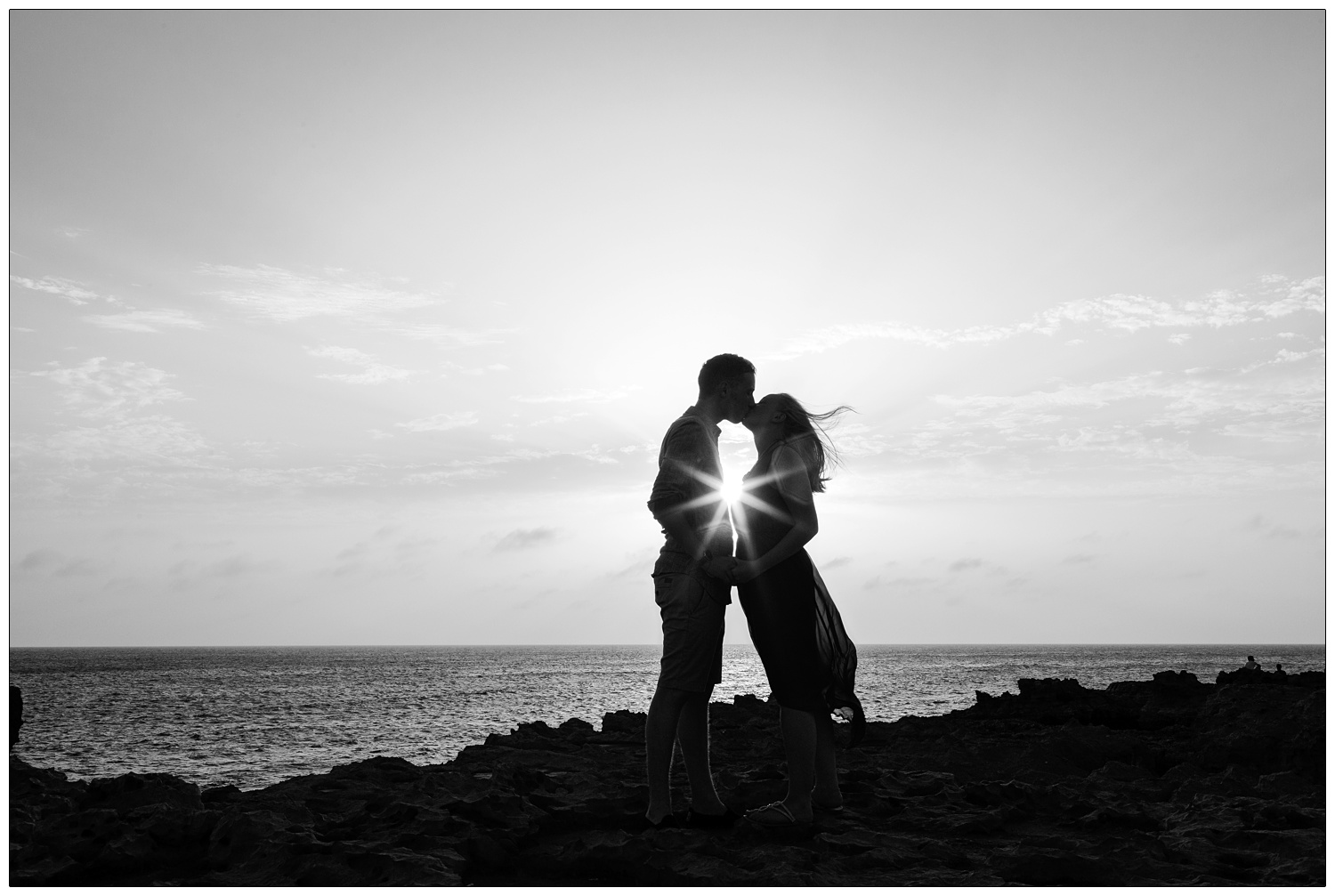 black and white silhouette of a newly married couple kissing at sunset on the Gozo coast near the Azure Window