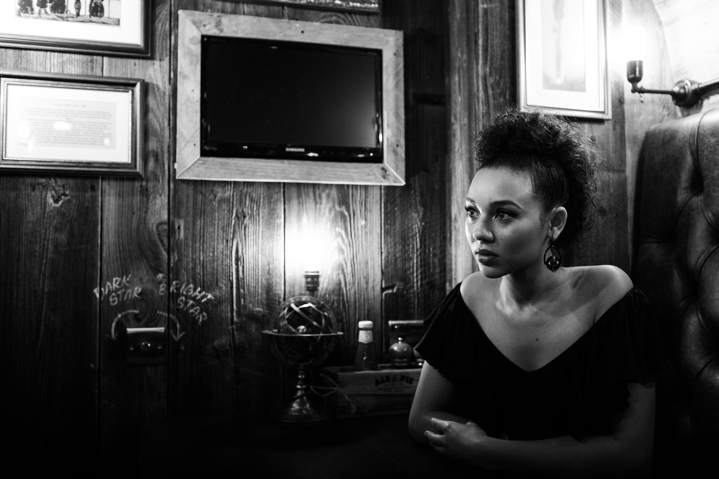 Black and white photograph of Unsigned Music Award winner Malaika sat in a pub