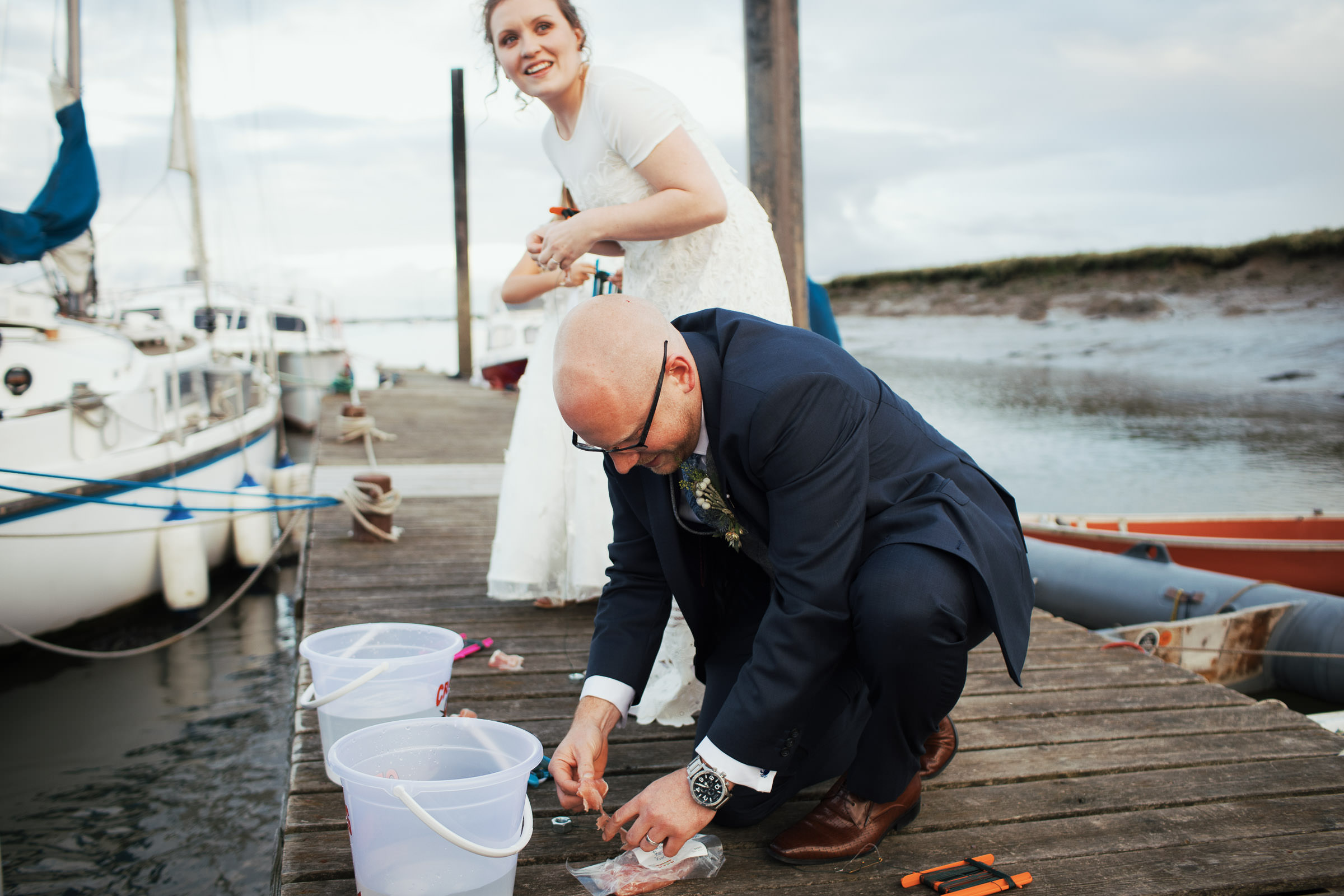 Bride and groom on the jetty crabbing on the River Crouch at wedding venue Brandy Hole Kingsman Point Kingsmans Farm Road, Hullbridge, Hockley SS5 6QB