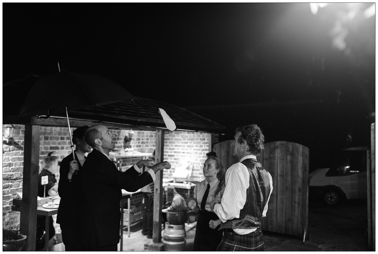 Nic of Alpheton Hall Barns with wedding guests flipping pizza dough in the air.