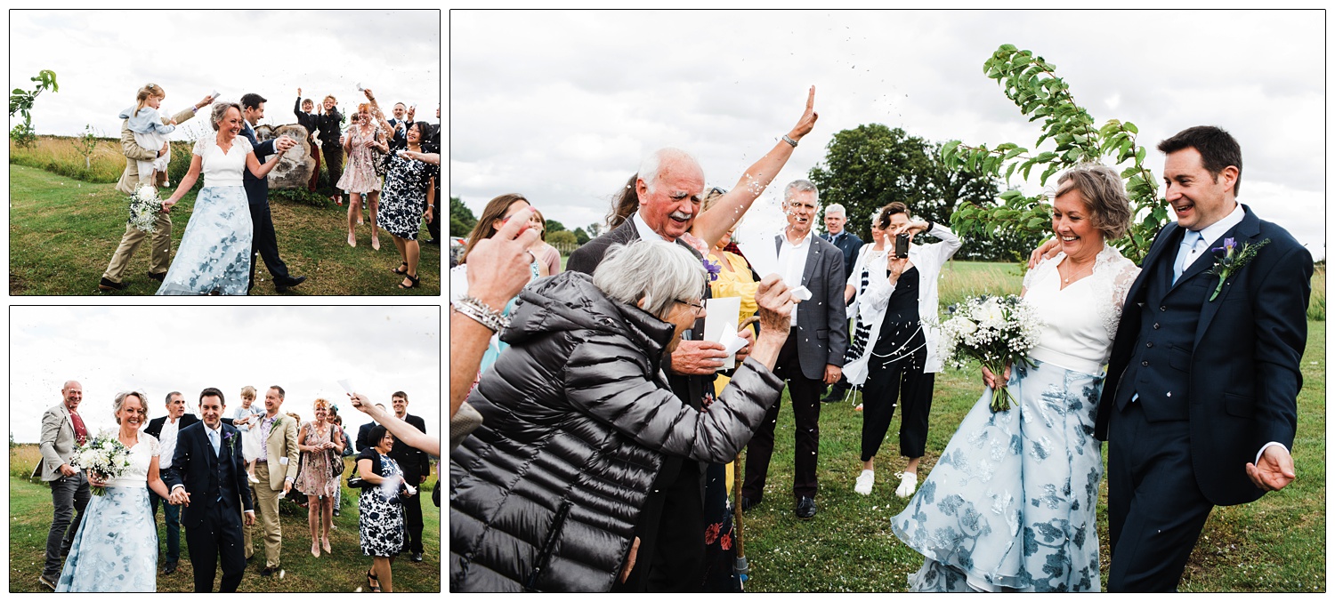 Wedding guests throwing confetti at bride and groom.