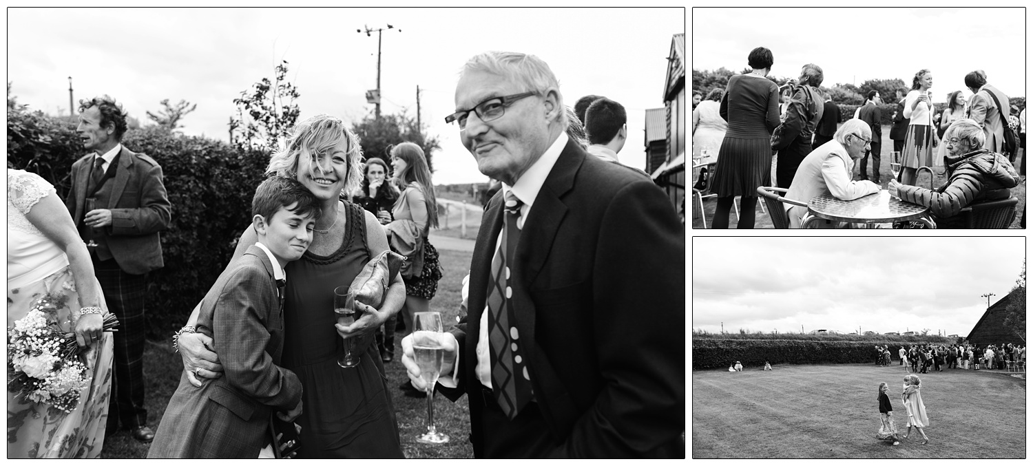 Black and white candid wedding photographs in the garden at Alpheton Hall Barns. Wedding guests enjoying themselves.
